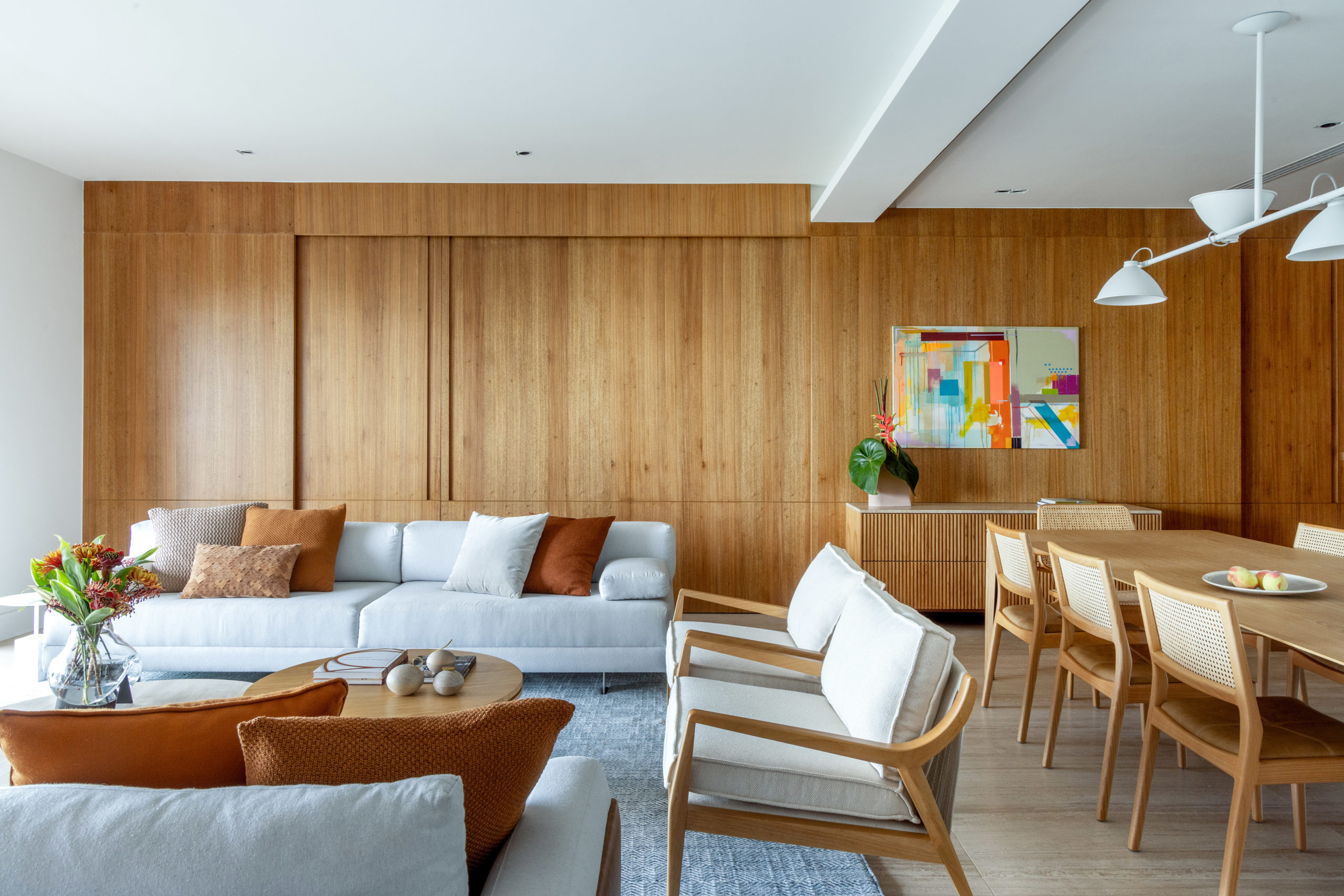 na foto salas de estar e jantar com parede em madeira