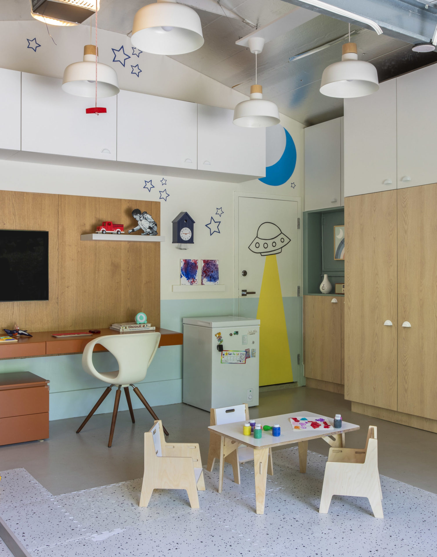 na foto uma brinquedoteca com uma mesa de trabalho