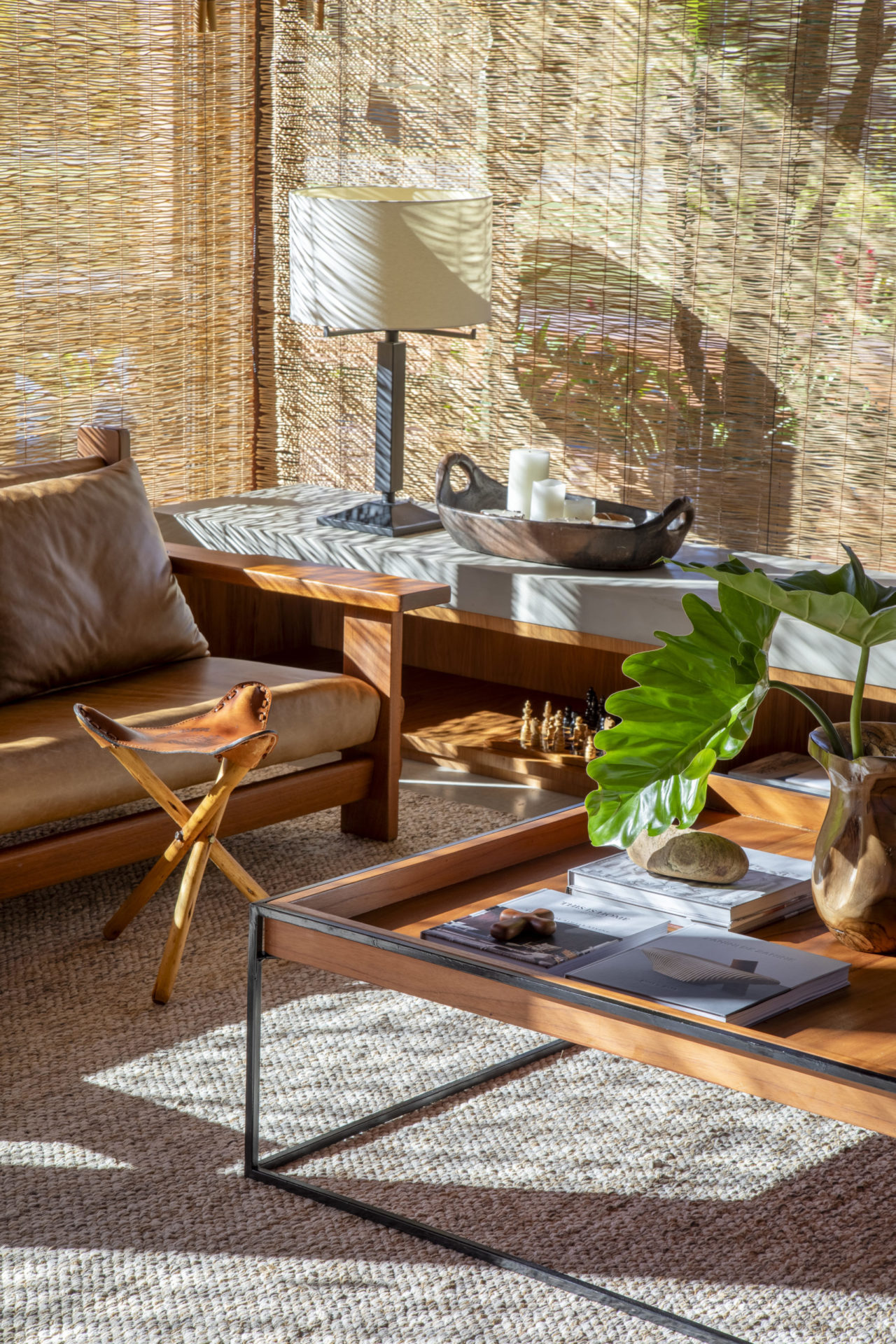 na foto sala de estar com sofá em couro, mesa de centro e aparador