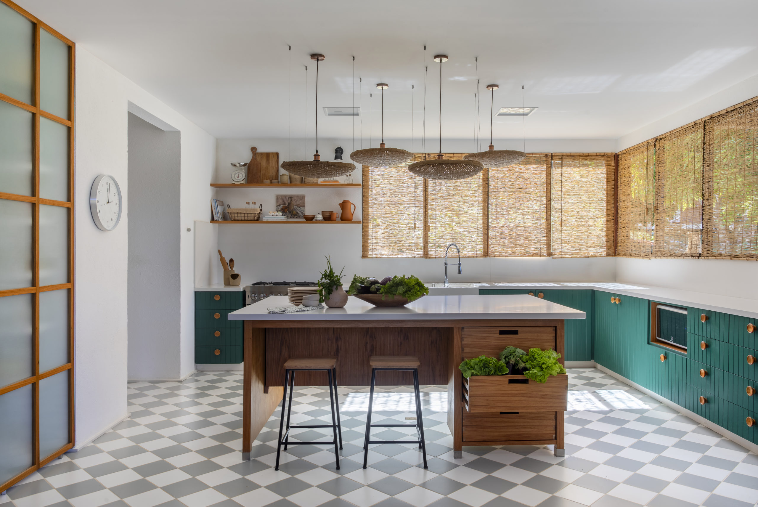 na foto cozinha ampla, com mesa lustres e janelas