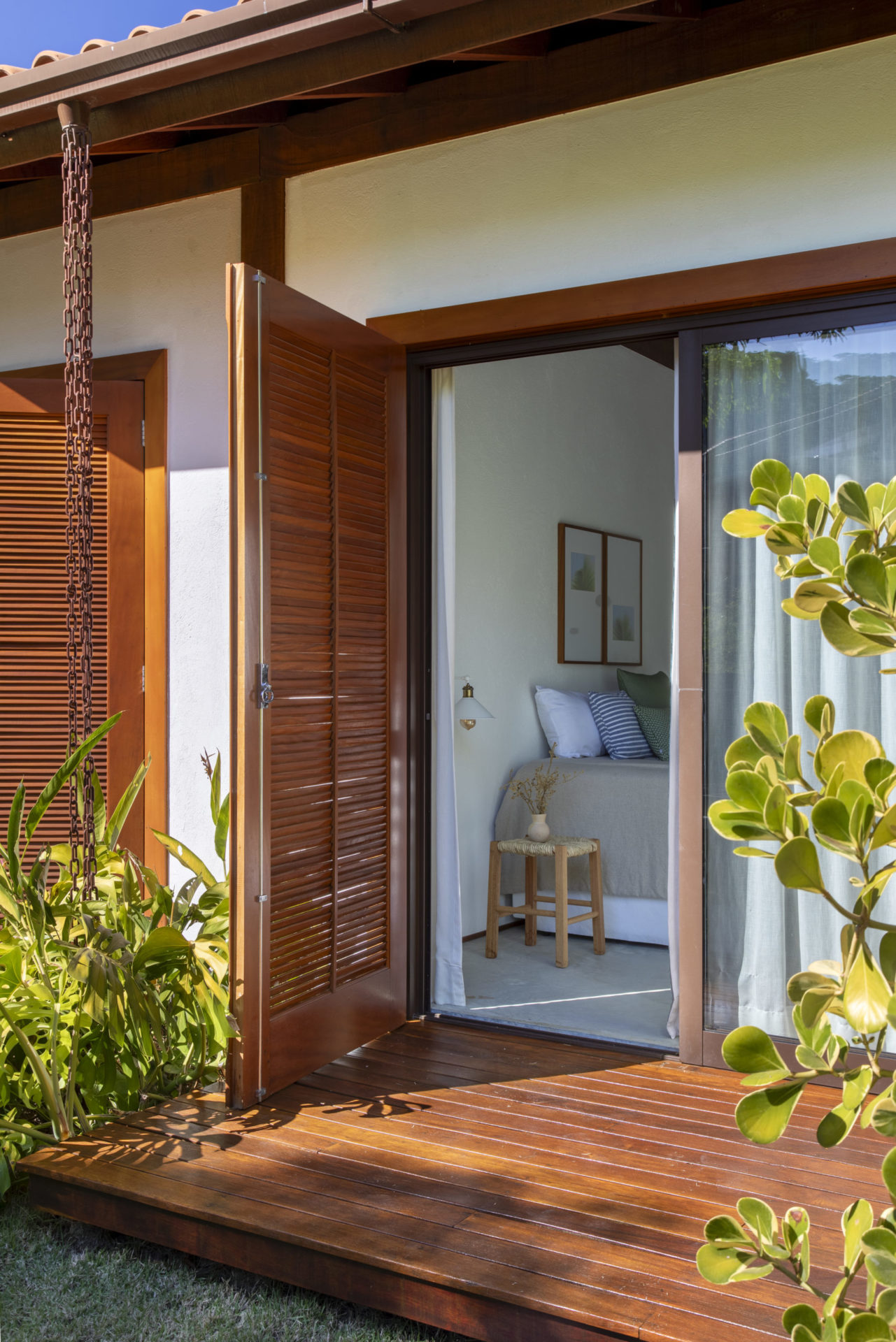 na foto quarto com porta de madeira aberta para o campo