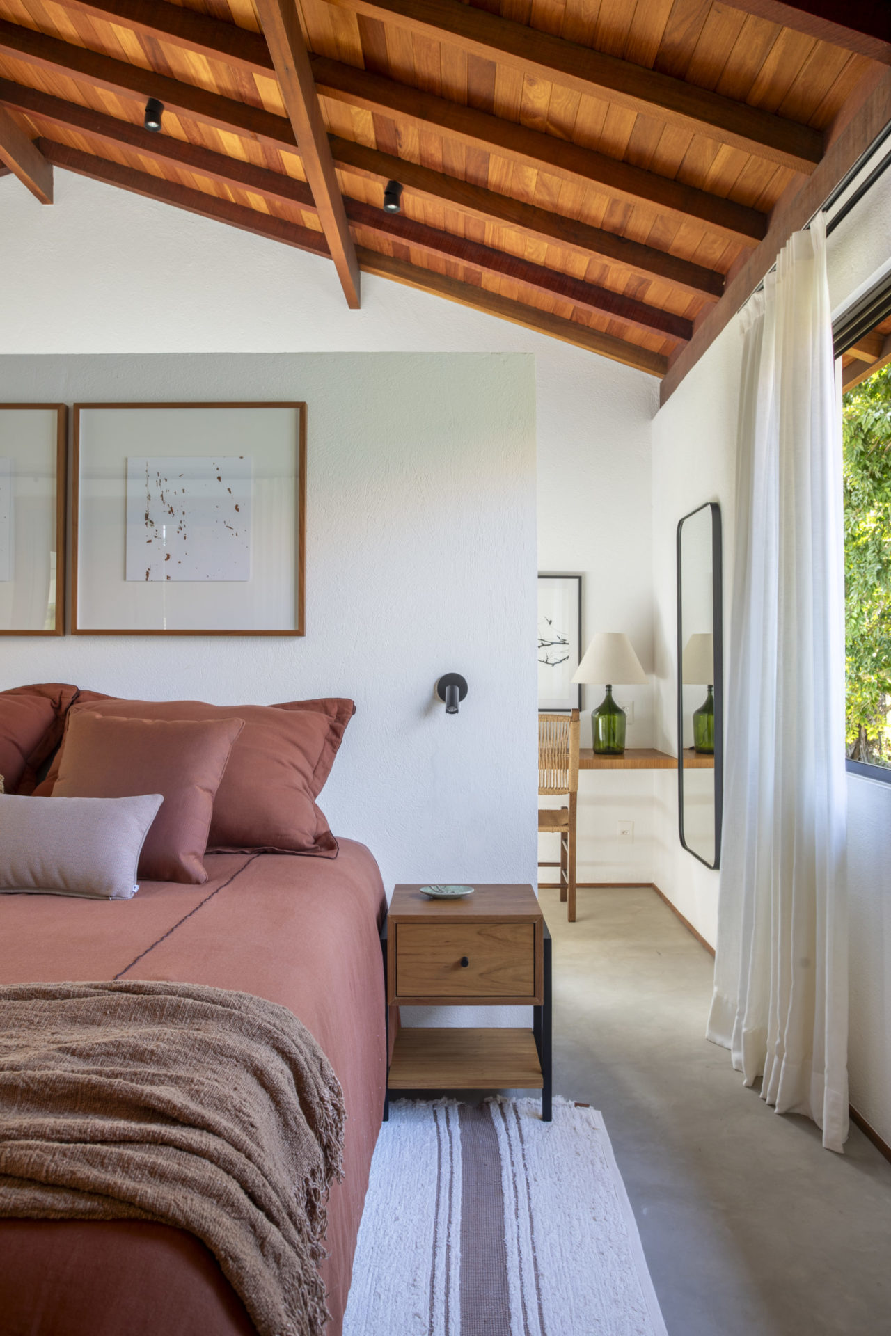 na foto quarto com cama de casal com vista para o campo e teto de madeira