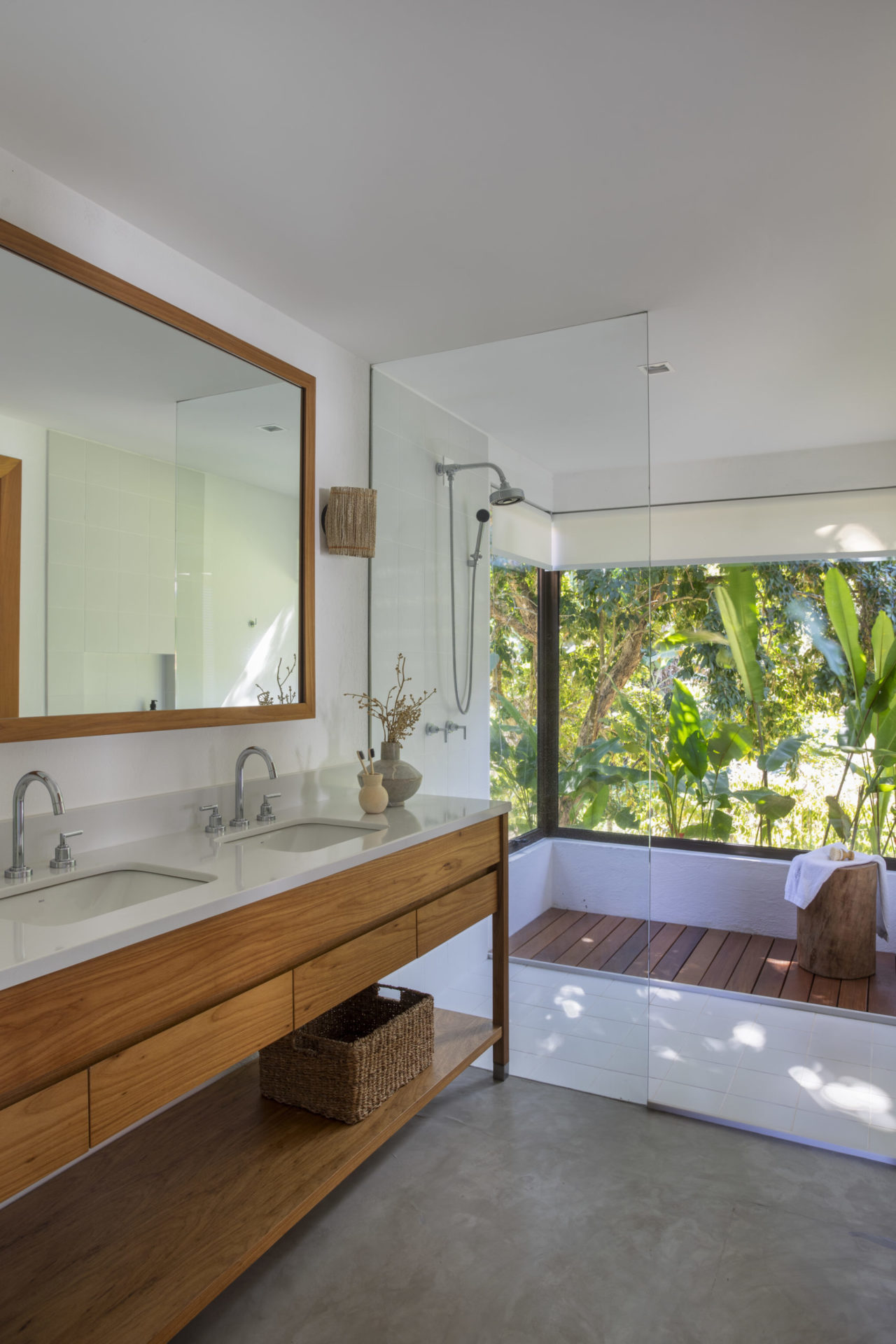 na foto banheiro com bancada de madeira e mármore, duas pias e janela