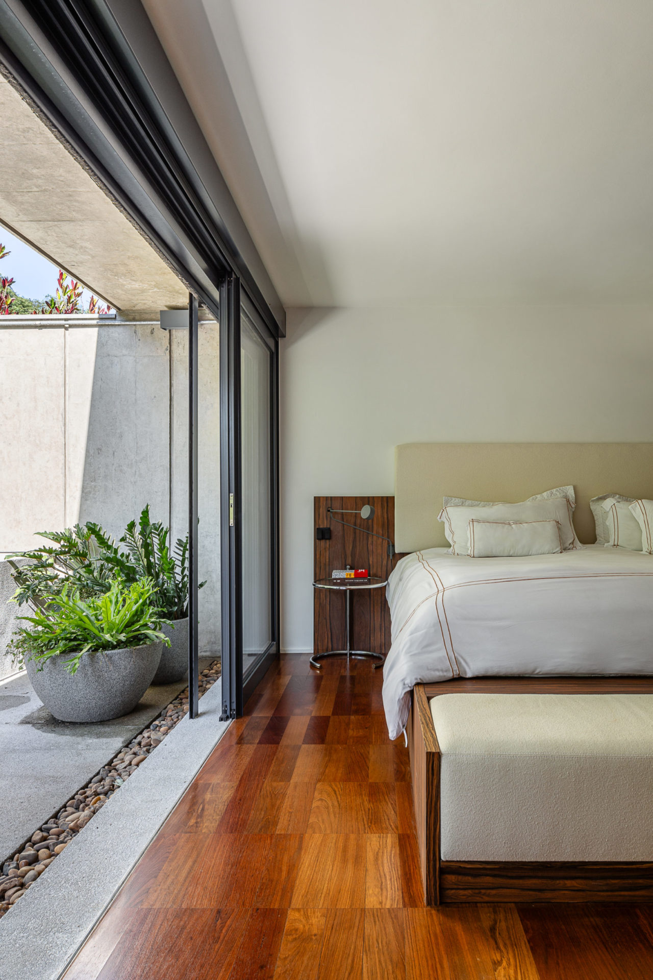 na foto um quarto com cama e varanda com plantas