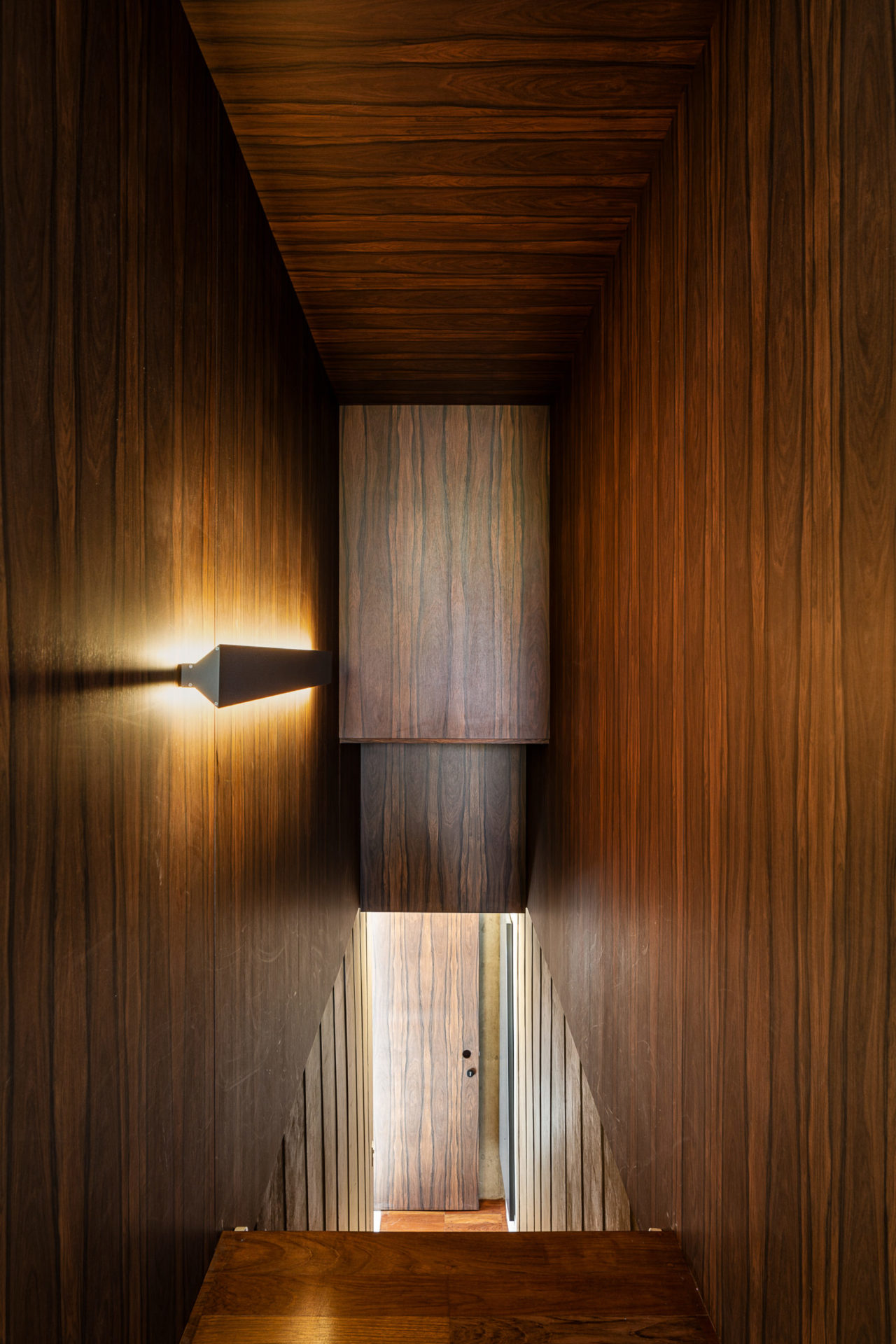 na foto espaço iluminado de casa dos anos 70 e uma escada