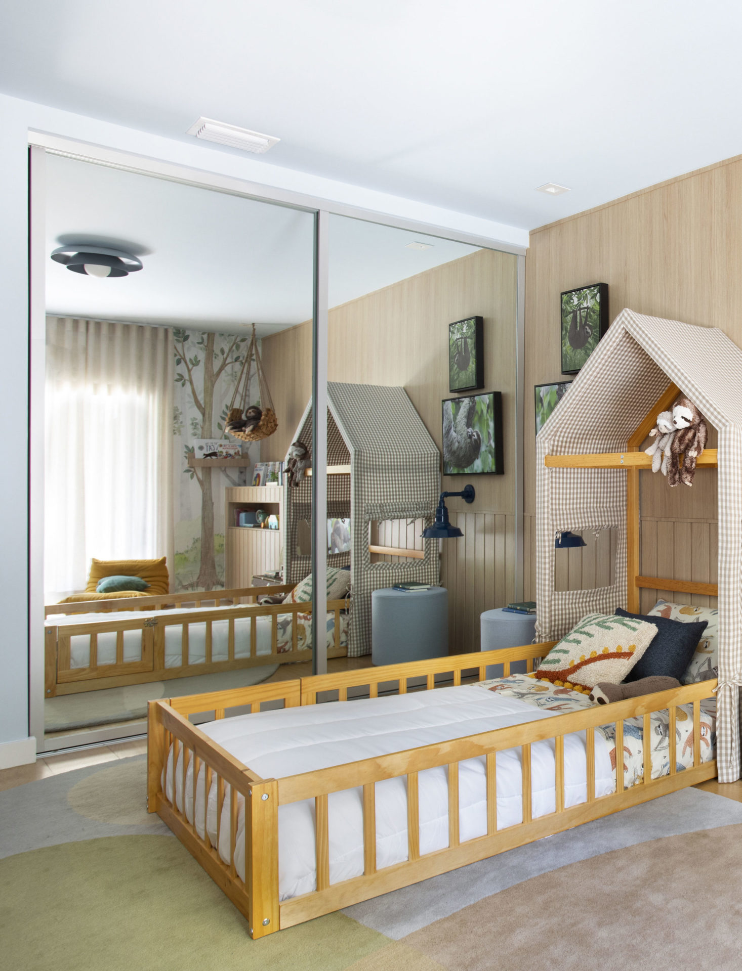 na foto quarto infantil com cama com cabeceira em formato de casa, arm´rio espelhado