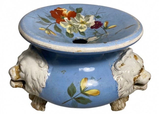 na foto um objeto de metal na cor azul com detalhes de flores