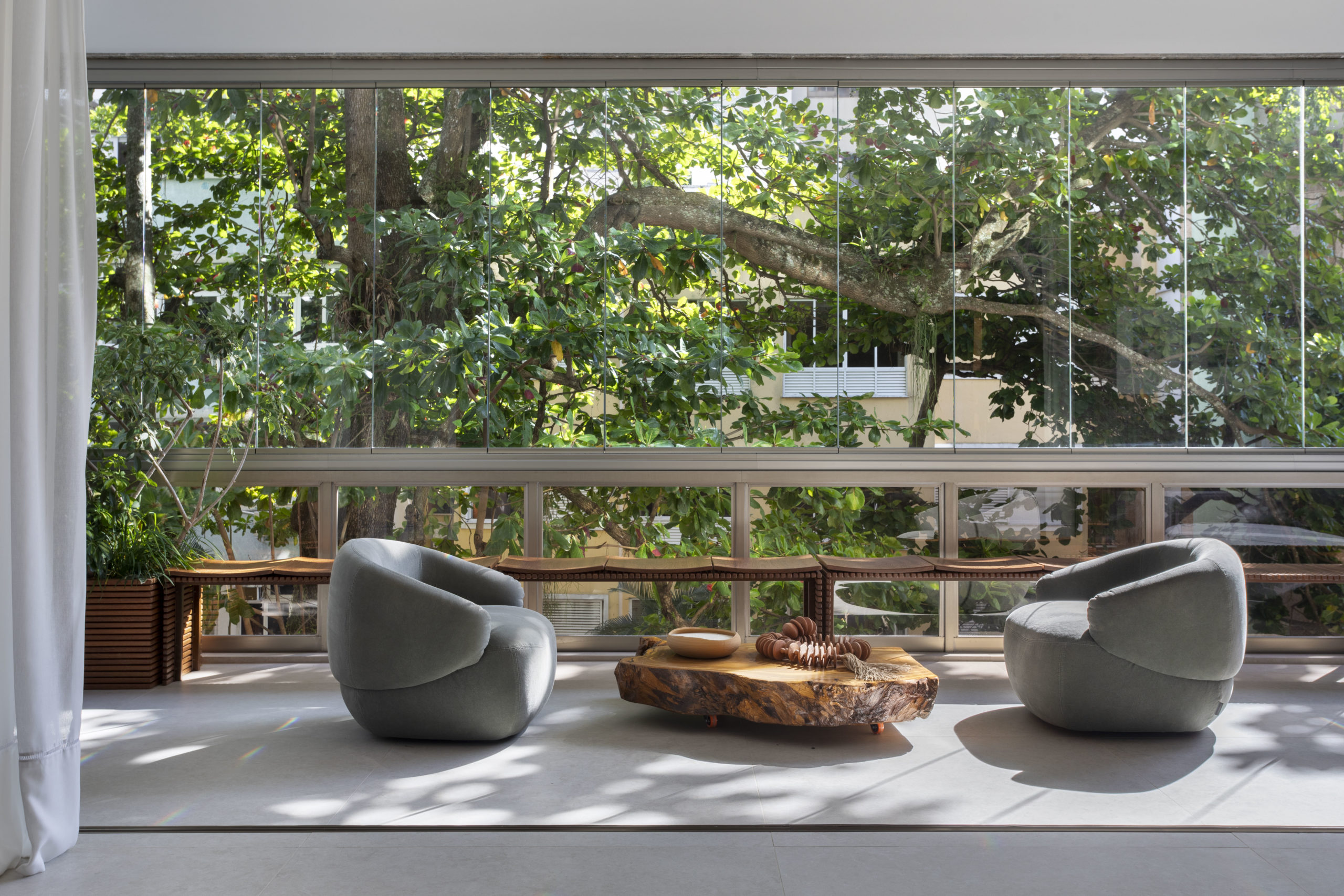 na foto uma varanda com duas poltronas com mesinha