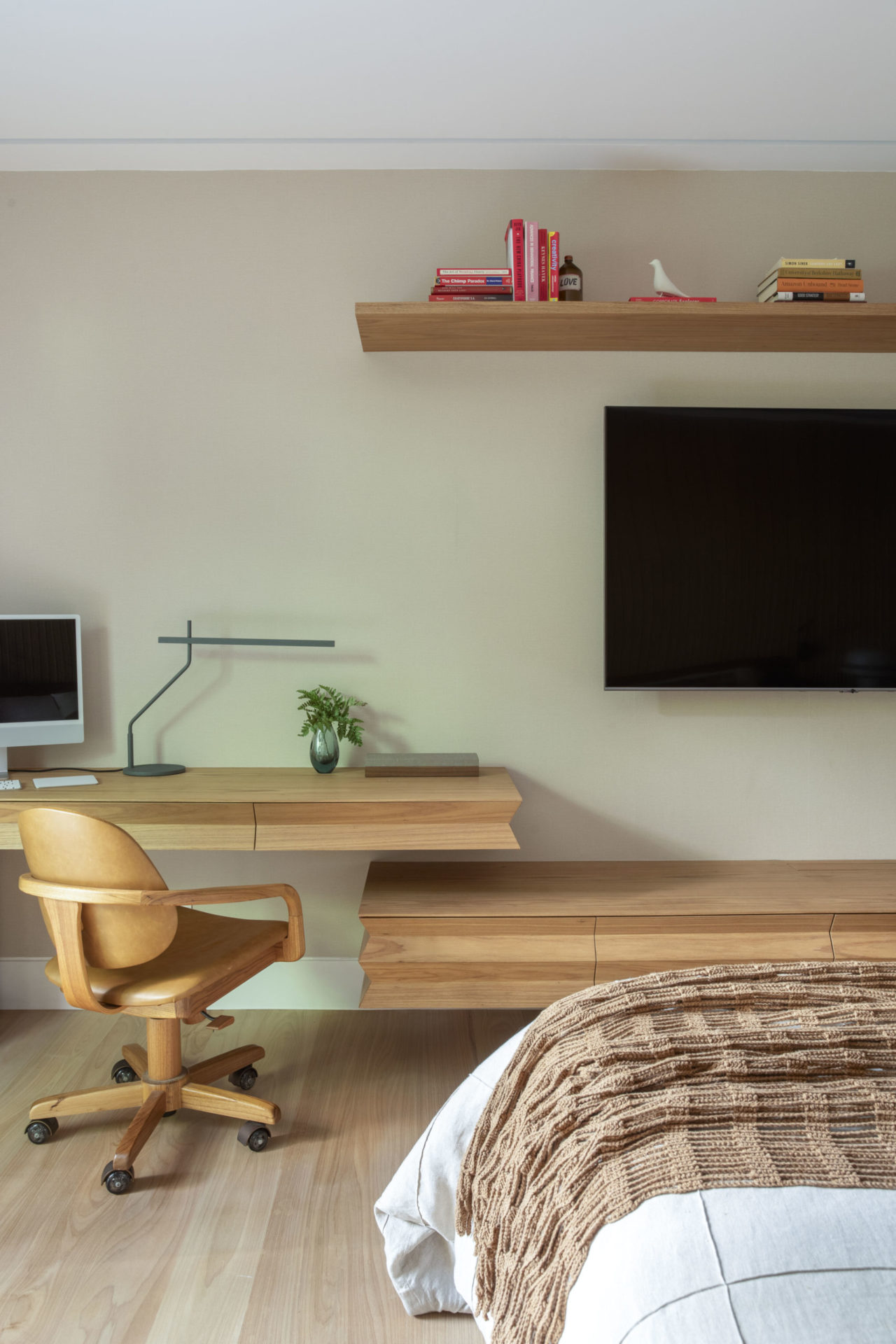 quarto de casal com rack e TV na parede