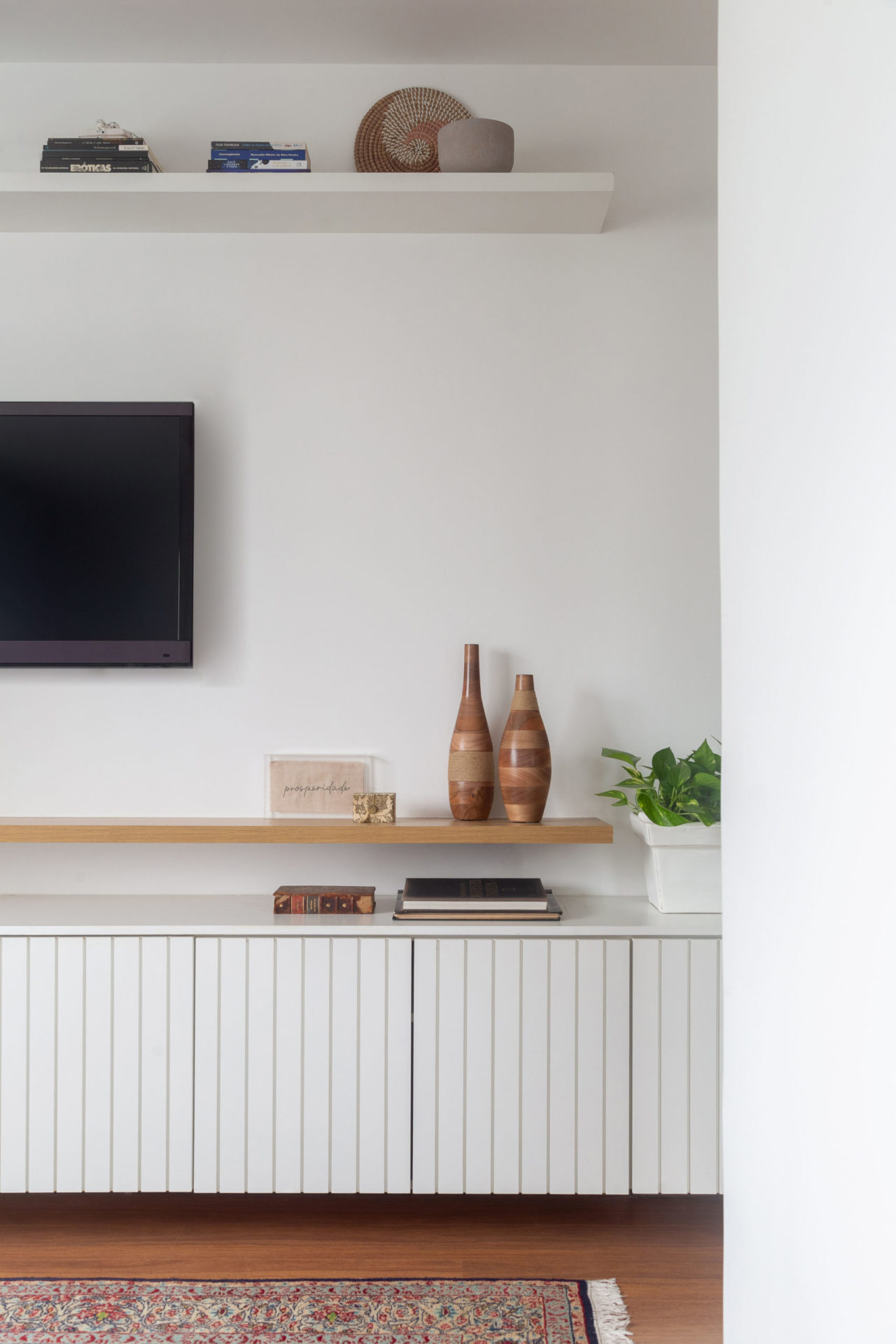 na foto móvel branco, TV e piso de madeira