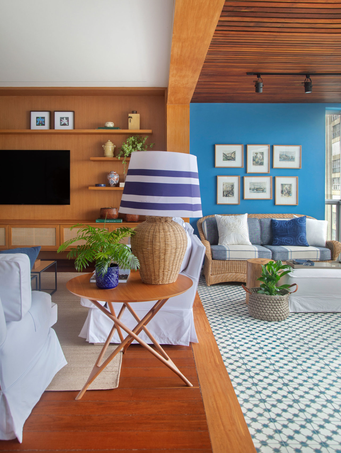 na foto sala de estar e TV e varanda com parede azul