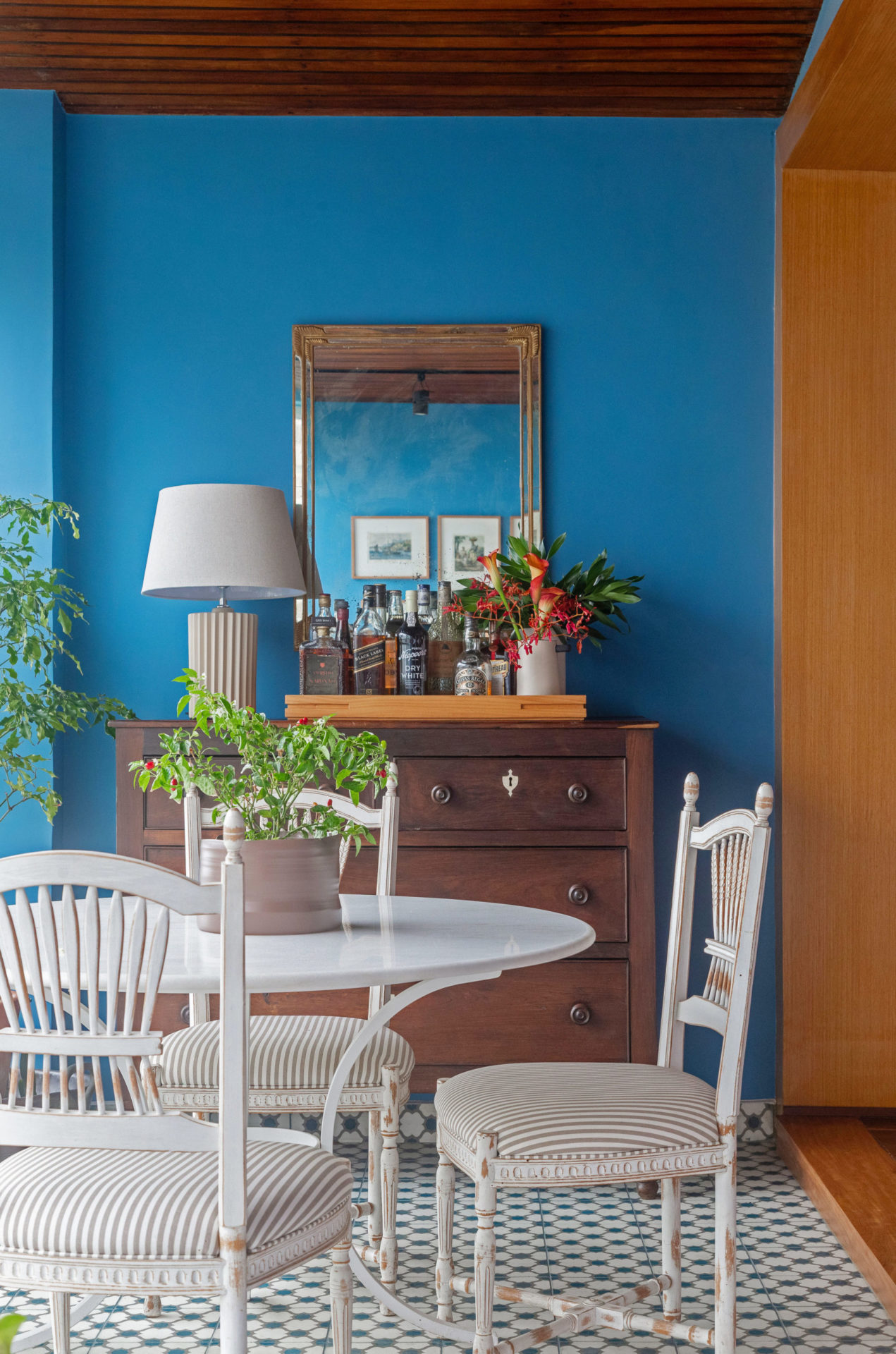 na foto varanda com parede azul, móvel de madeira e mesa