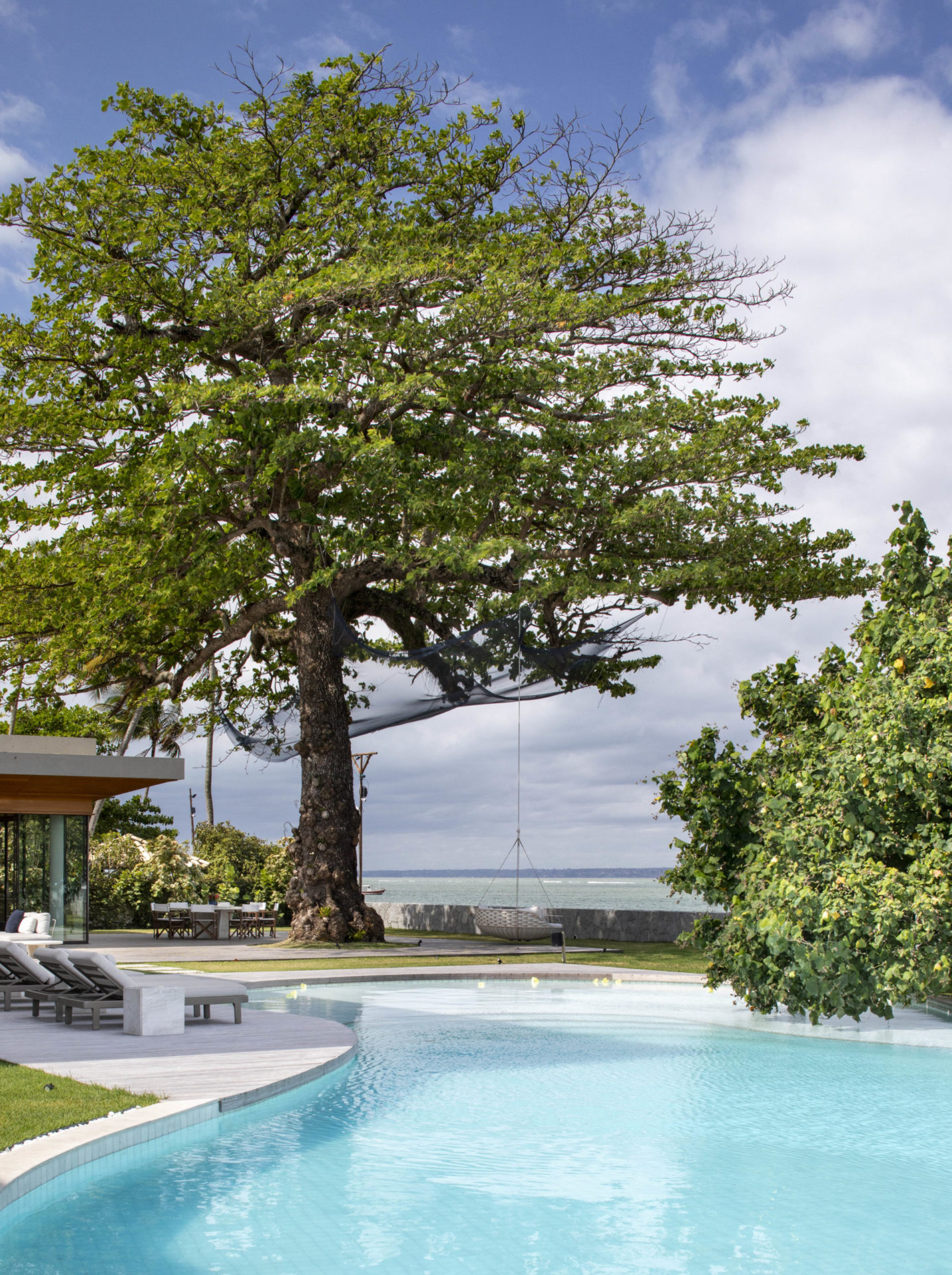 casa de praia com piscina e uma amendoeira
