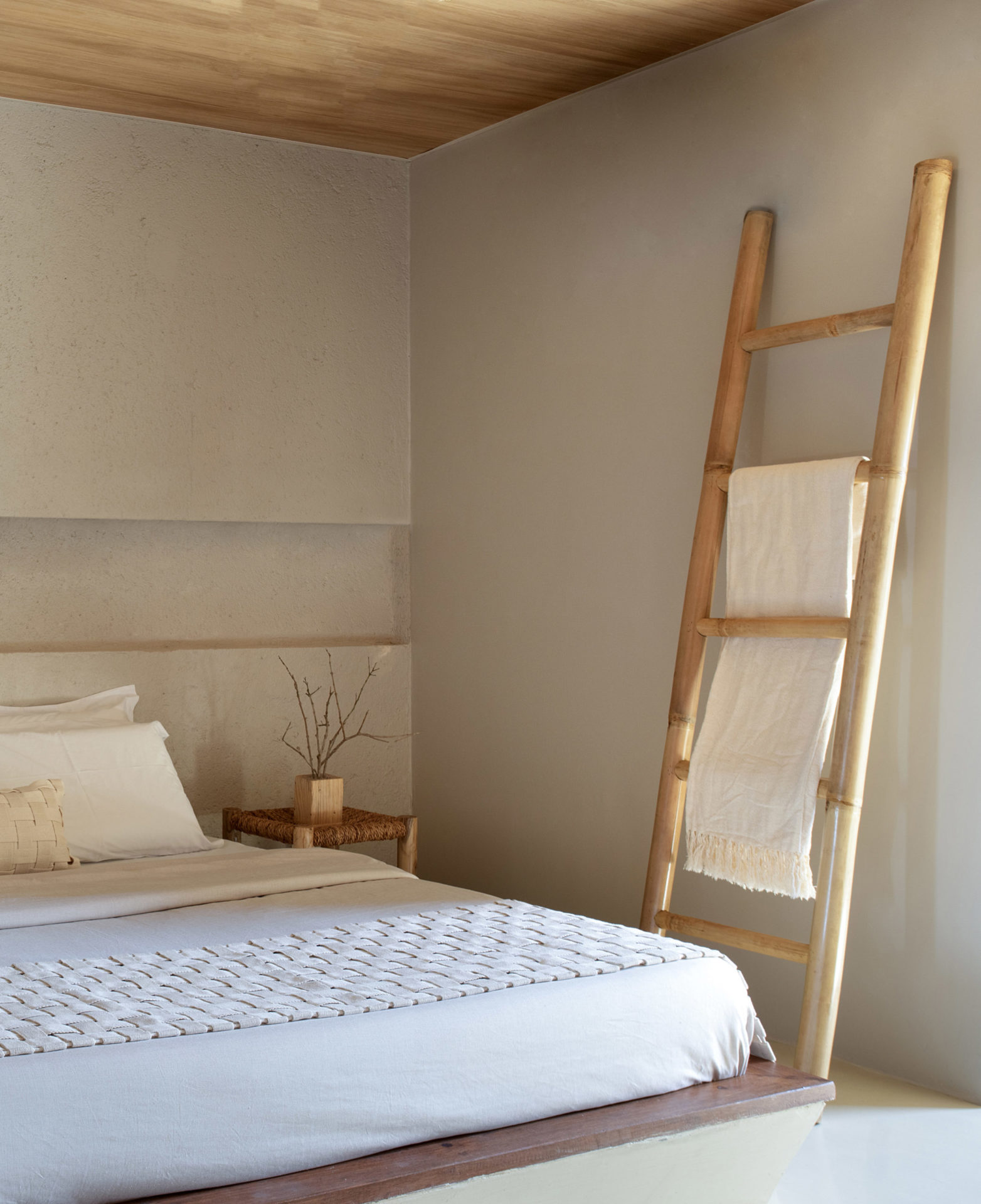 na foto o interior de uma casa. Uma cama e uma escada em tons de bege