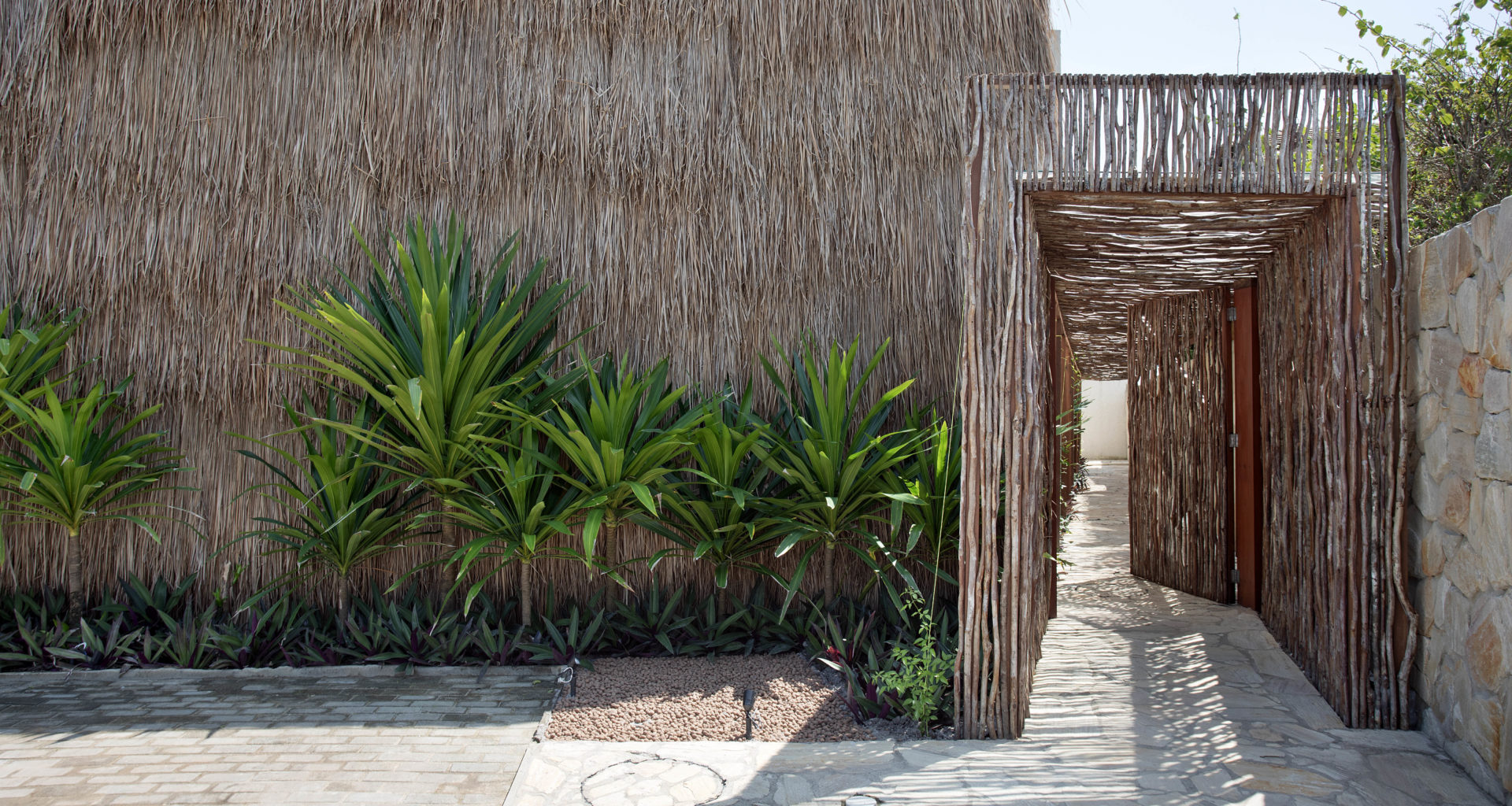 na foto uma casa com fachada inspirada em uma oca