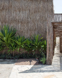 na foto uma casa com fachada inspirada em uma oca