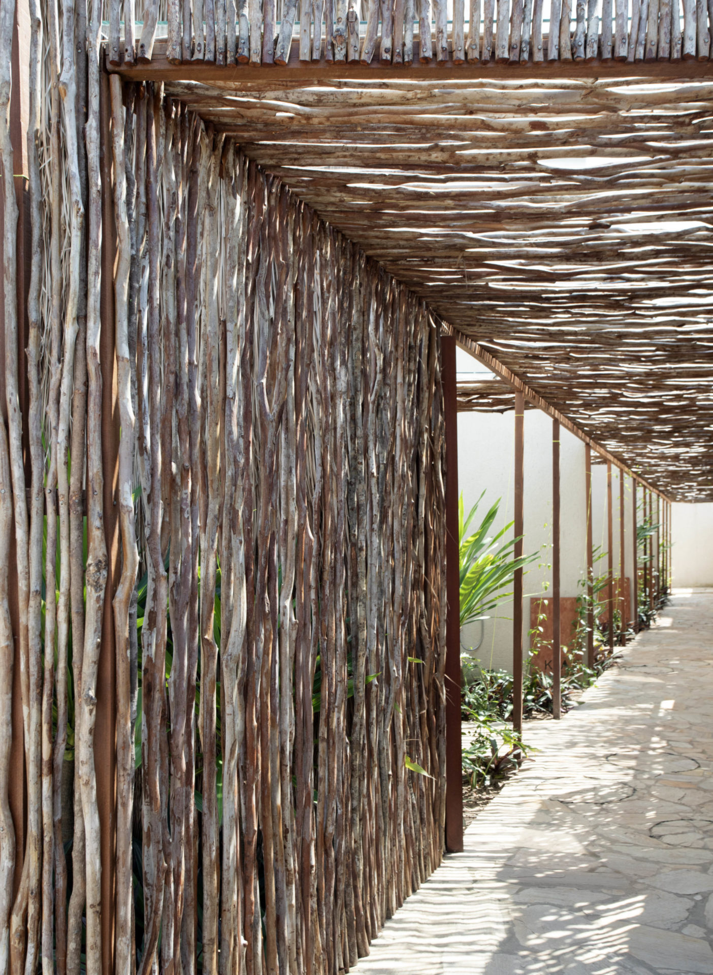 na foto um túnel dentro de uma casa inspirada em uma oca