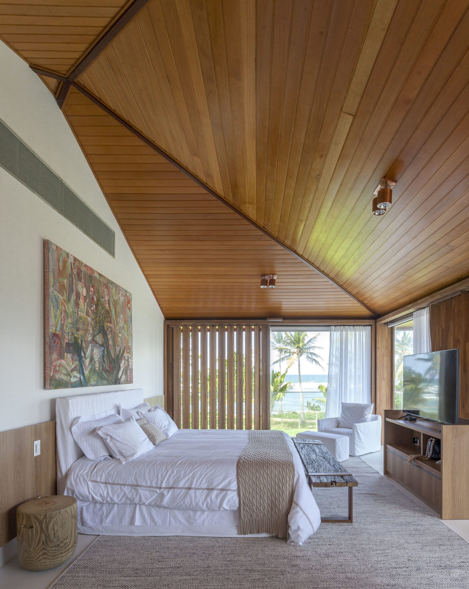 na foto suíte principal com TV e vista mar