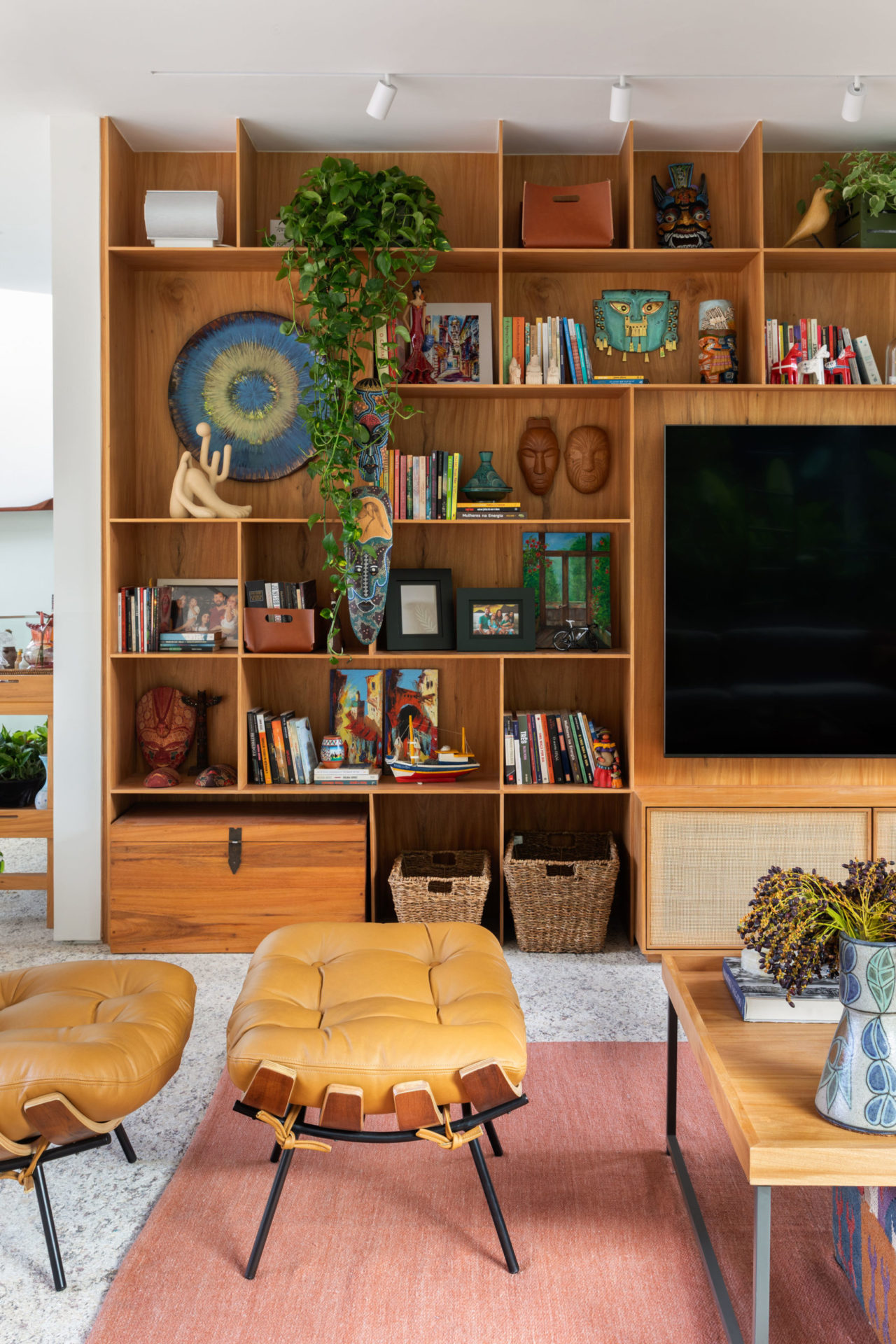 na foto sala com estante de madeira, baqueta mole em couro e mesa de centro