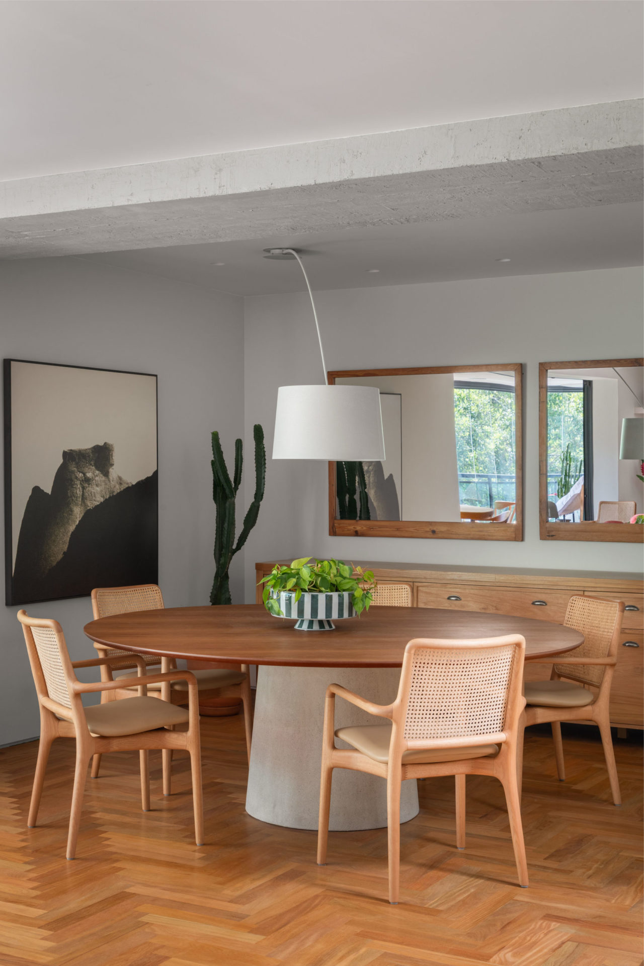 sala de duplex com mesa de jantar, luminária e espelhos na parede