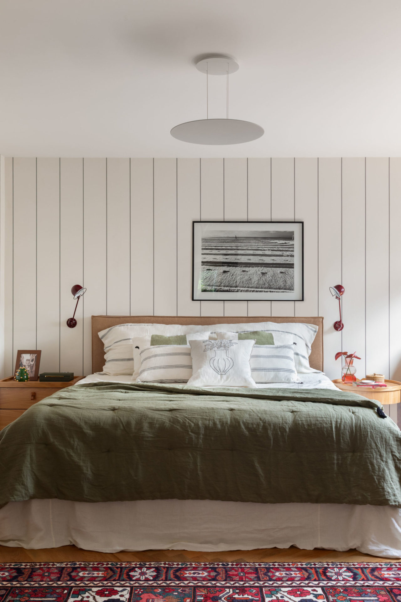 na foto quarto com cama de casal, quadro na parede e duas mesas de cabeceira