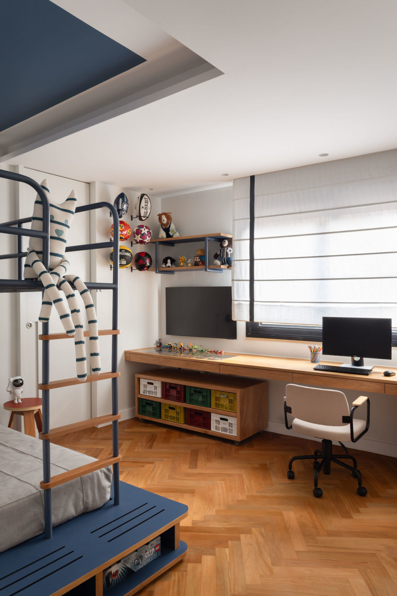 na foto quarto infantil com bicama, mesa com tv e computador