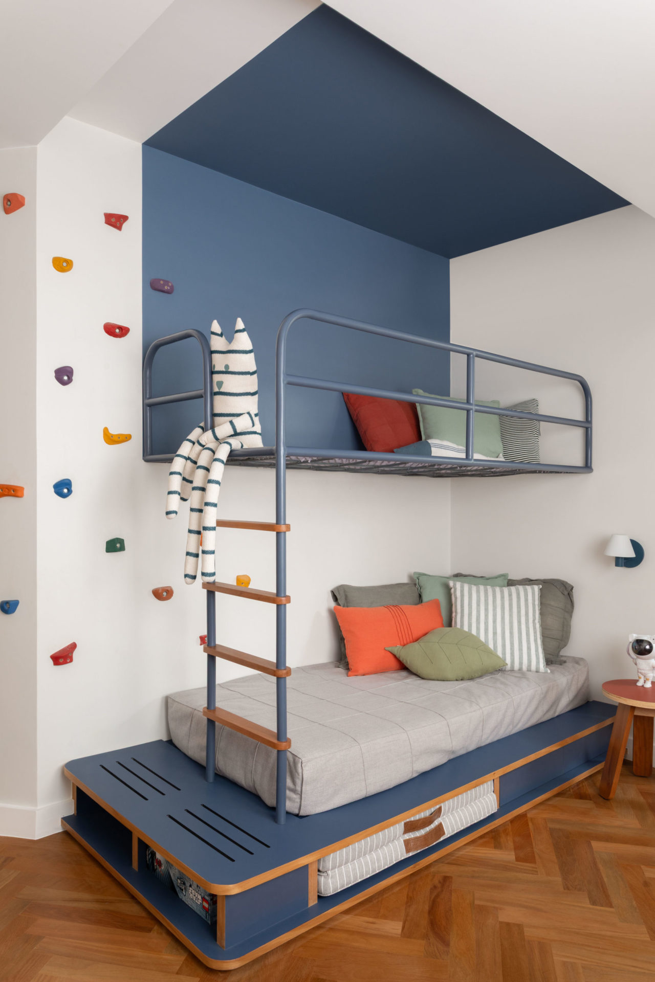 na foto quarto infantil com uma bicama com parede metade azul e metade branca