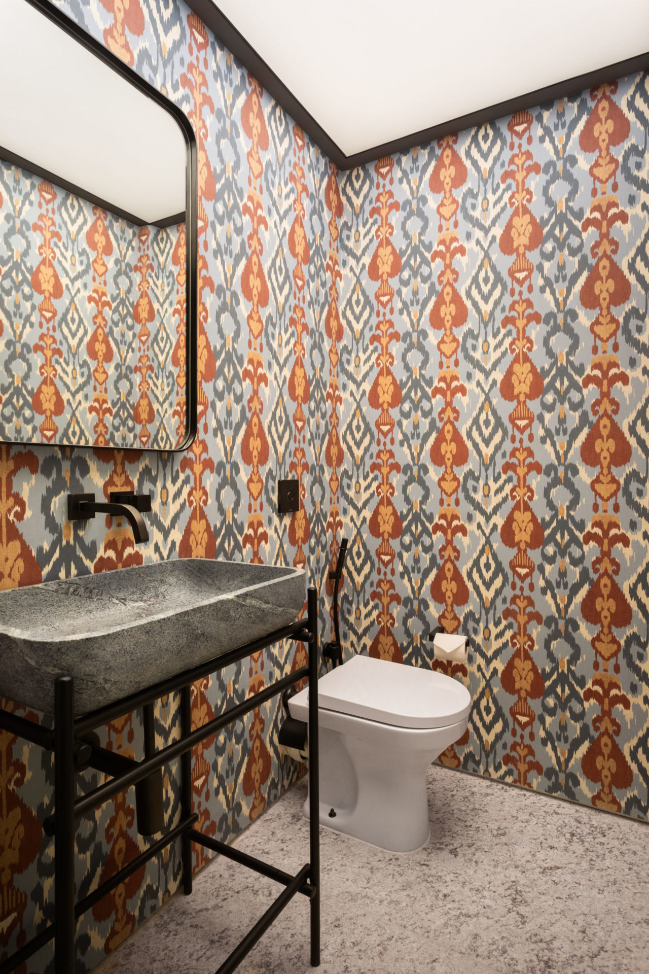 na foto lavabo com papel de parede colorido, espelho, pia e vaso