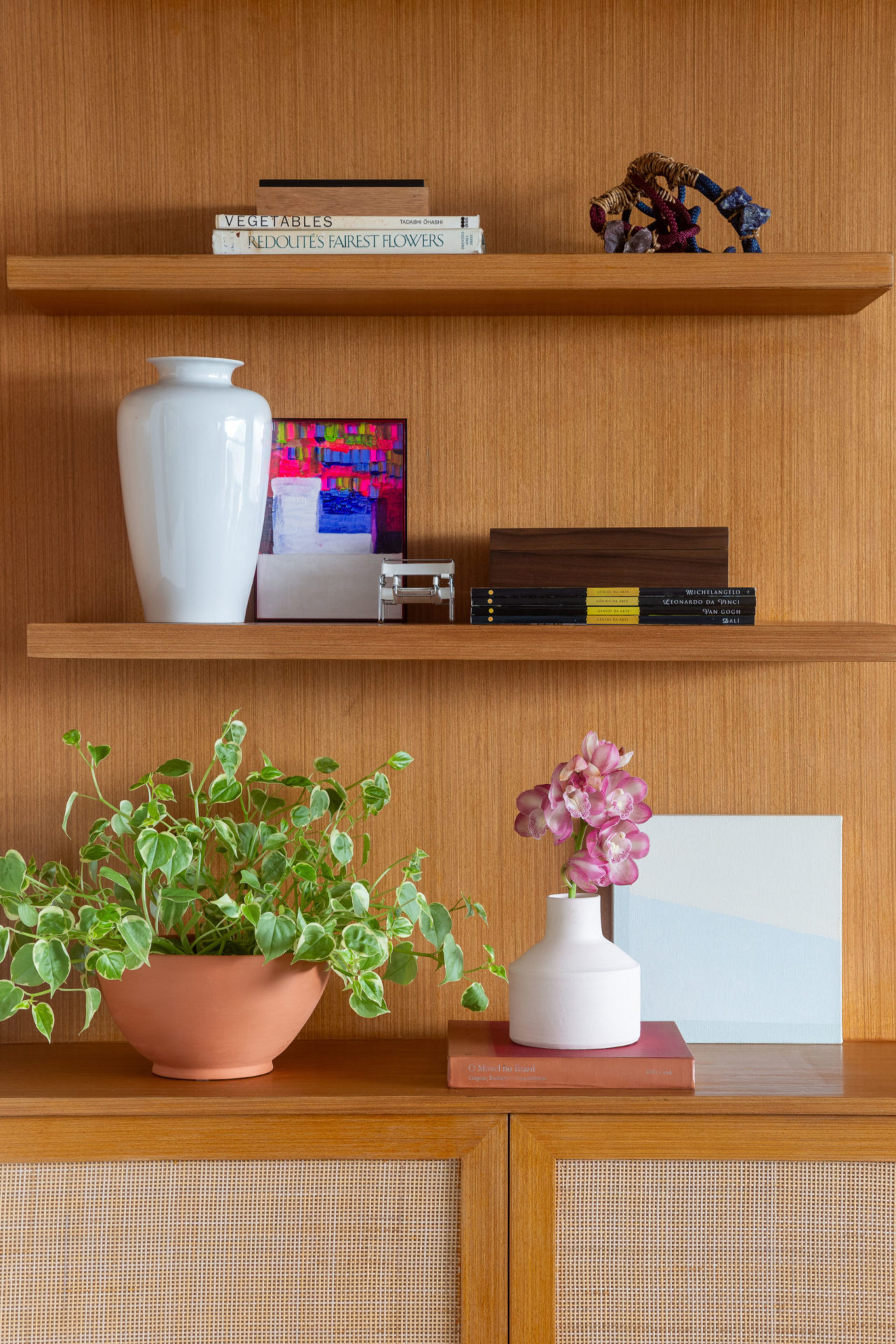 na foto parte de uma estante de madeira com plantas e flores
