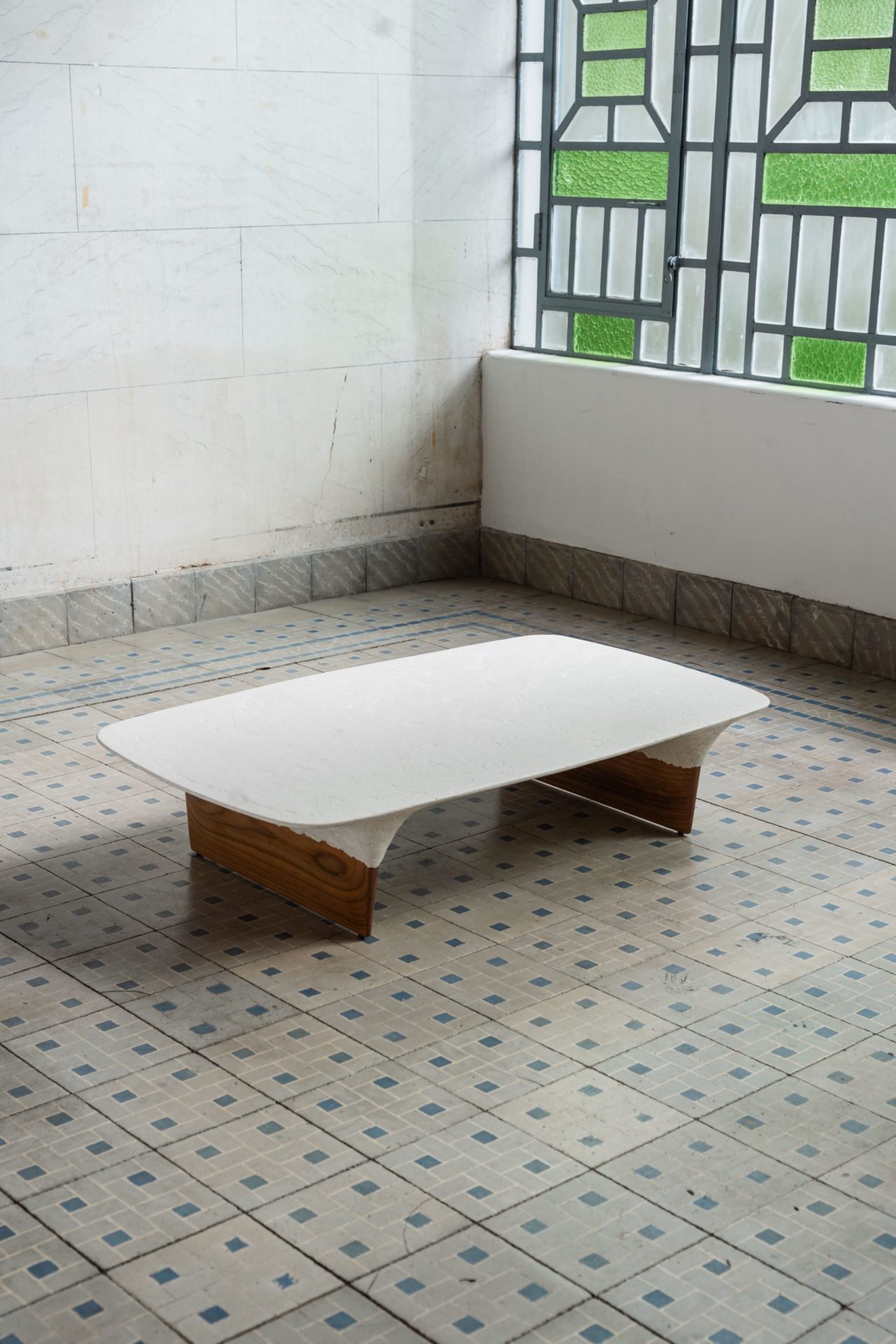 na foto uma sala com um banco branco e janela