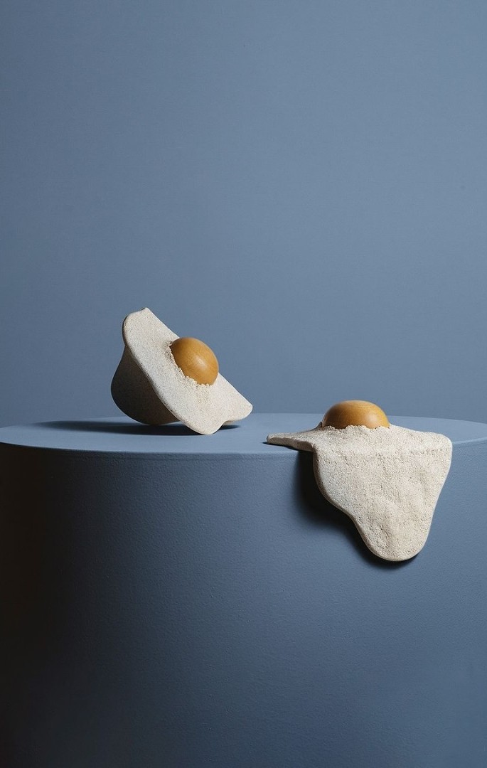 na foto duas esculturas em formato de ovos fritos