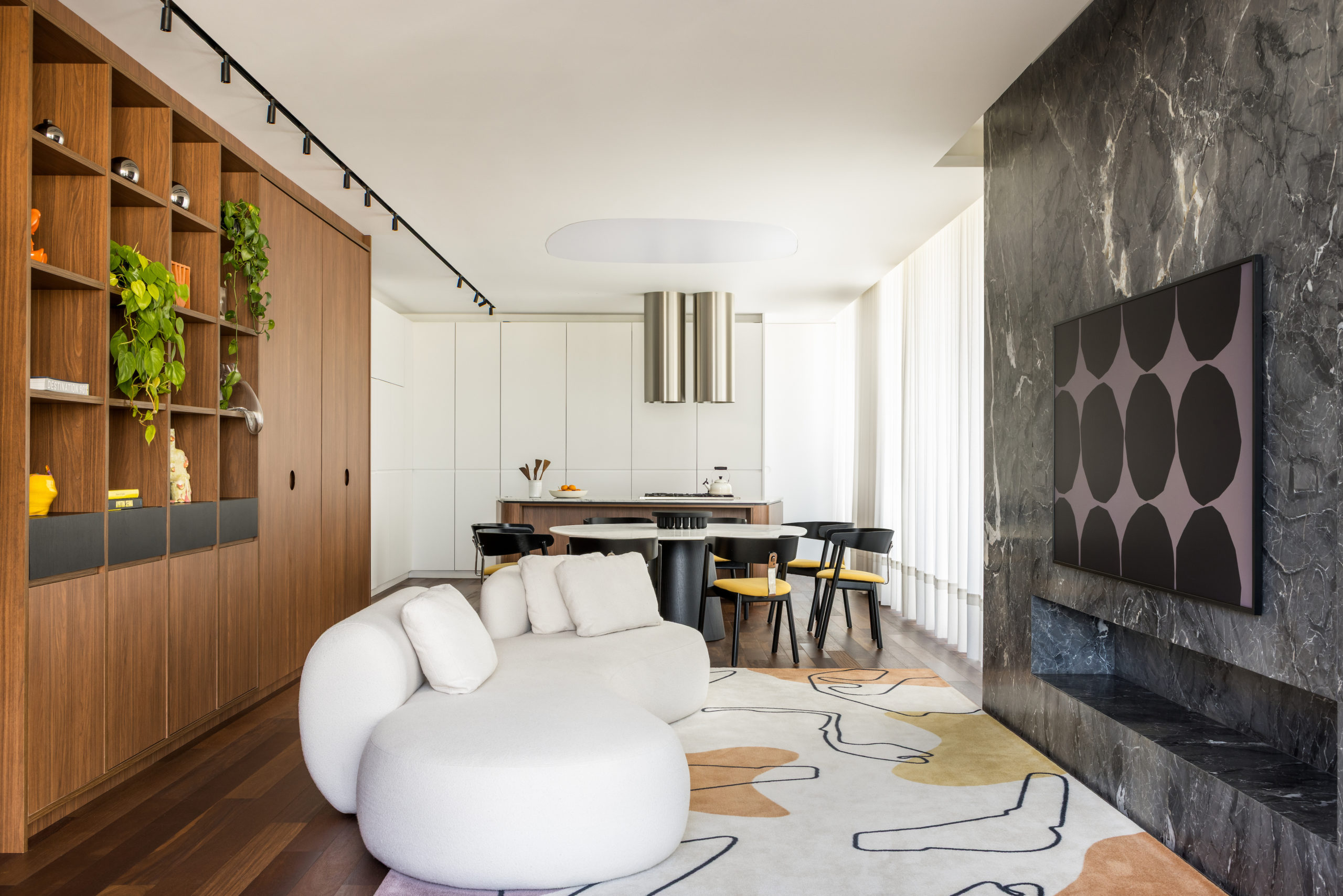 na foto living integrado à cozinha nas cores branco, preto e madeira