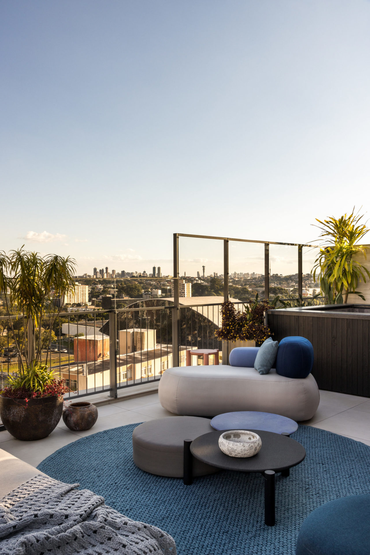 na foto varanda de apartamento com sofá, mesinhas e muitas plantas