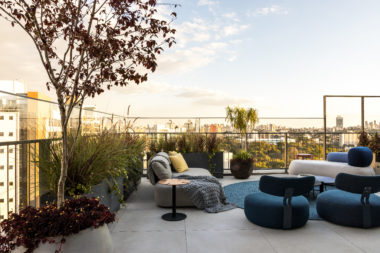 na foto varanda de duplex com sofás, puffs e mesinhas