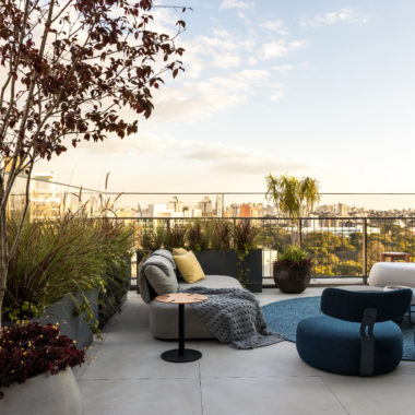 na foto varanda de duplex com sofás, puffs e mesinhas