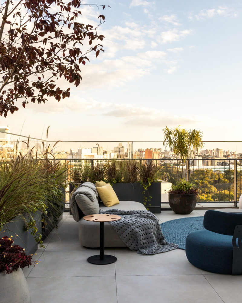 na foto varanda de duplex com sofás, puffs e mesinhas