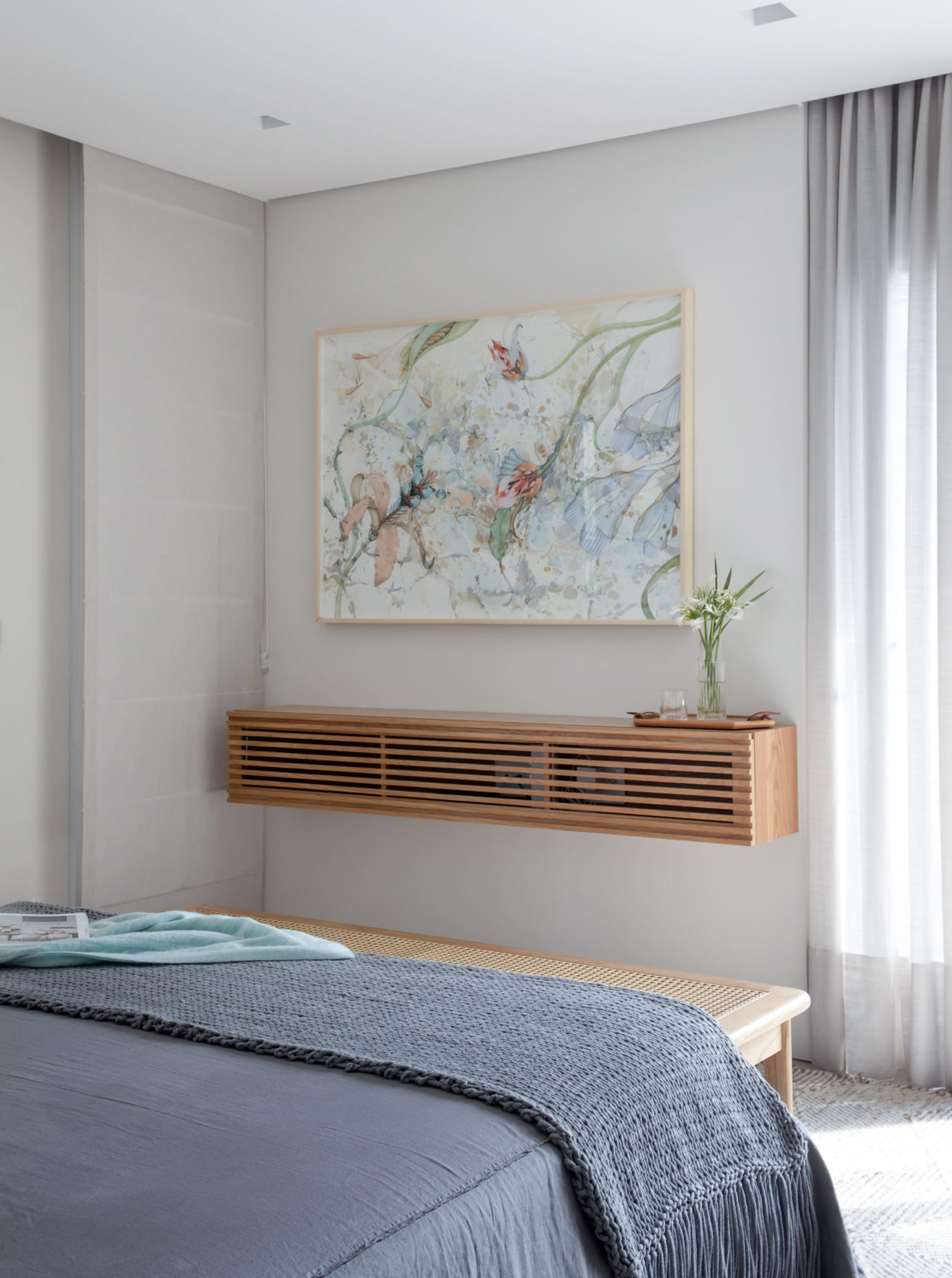 na foto quarto de casal com aparador preso na prede e quadro floral