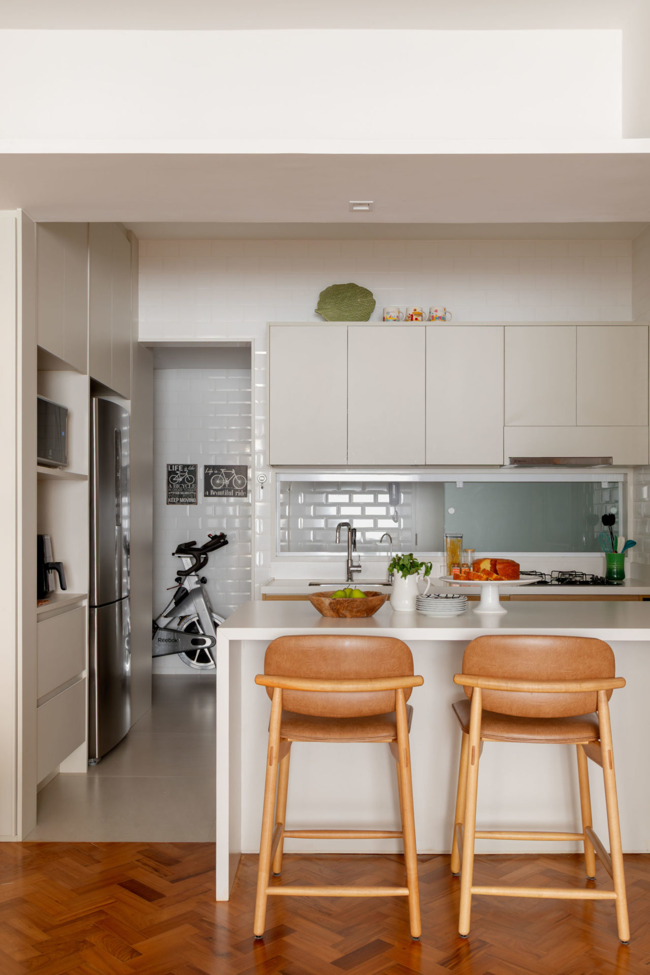 na foto cozinha com armários, banquetas de couro