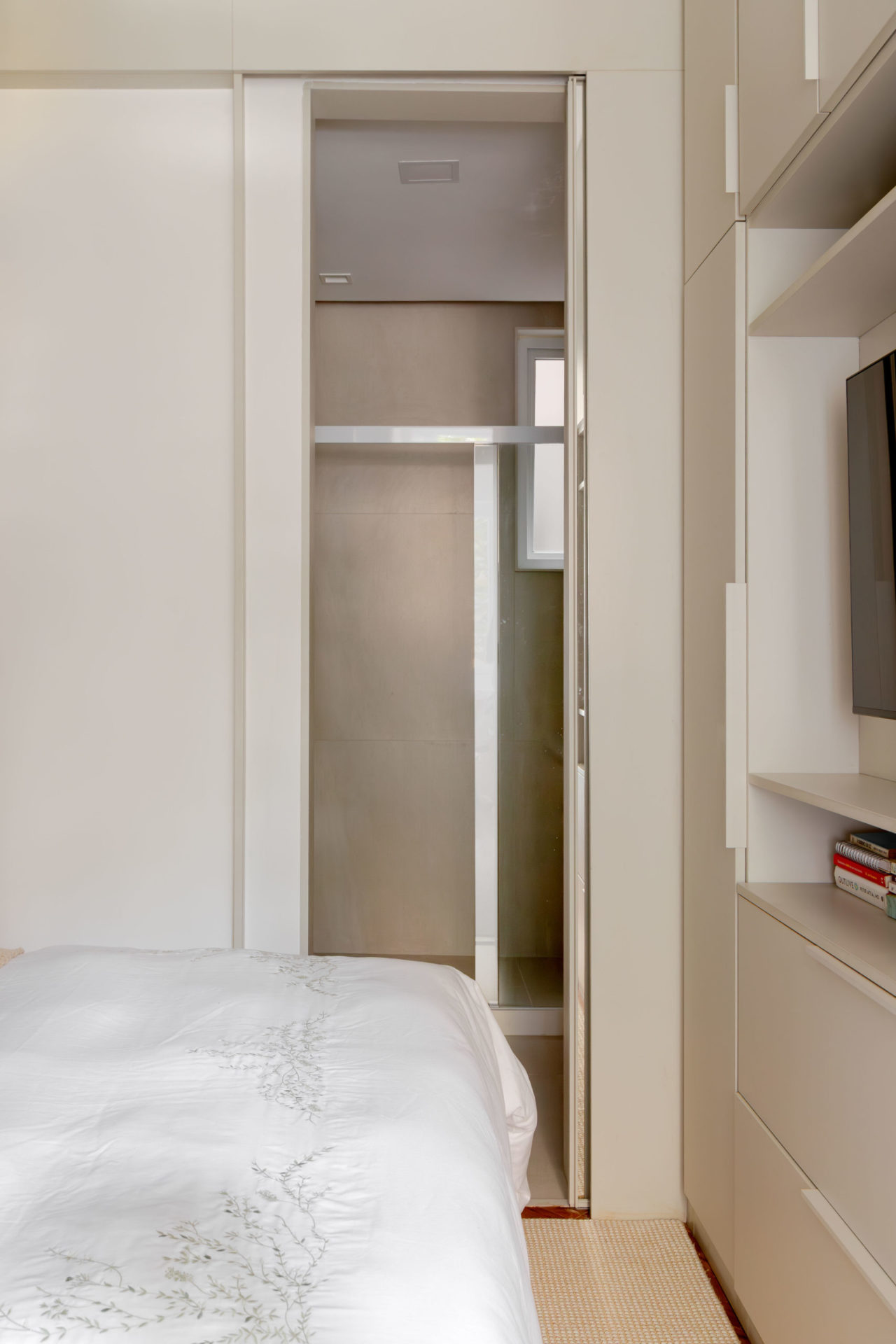 na foto quarto com armário com espelho e banheiro