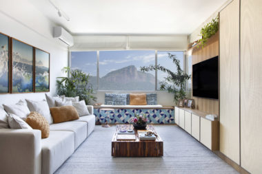 na foto sala de estar com vista para o Cristo Redentor com painel de madeira para TV