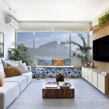 na foto sala de estar com vista para o Cristo Redentor com painel de madeira para TV