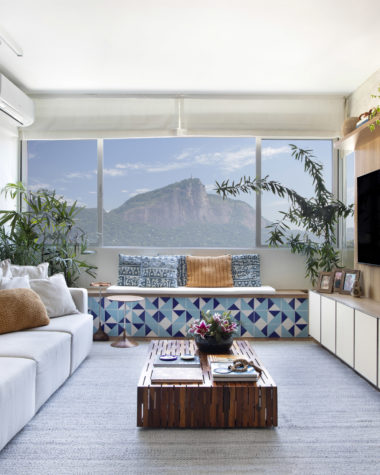 na foto sala de estar com vista para o Cristo Redentor com painel de madeira para TV
