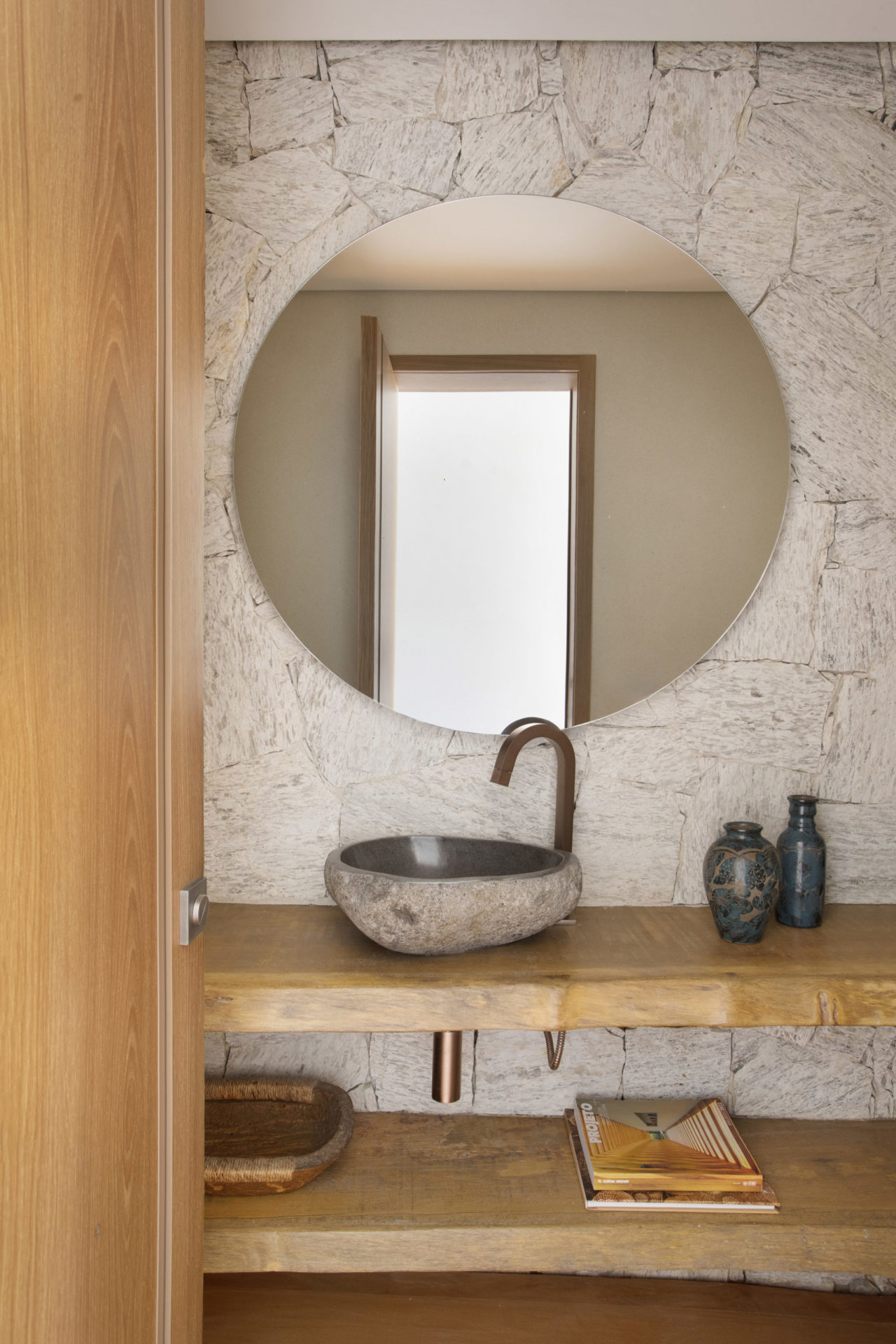 na foto lavabo com porta e bancada em madeira maciça