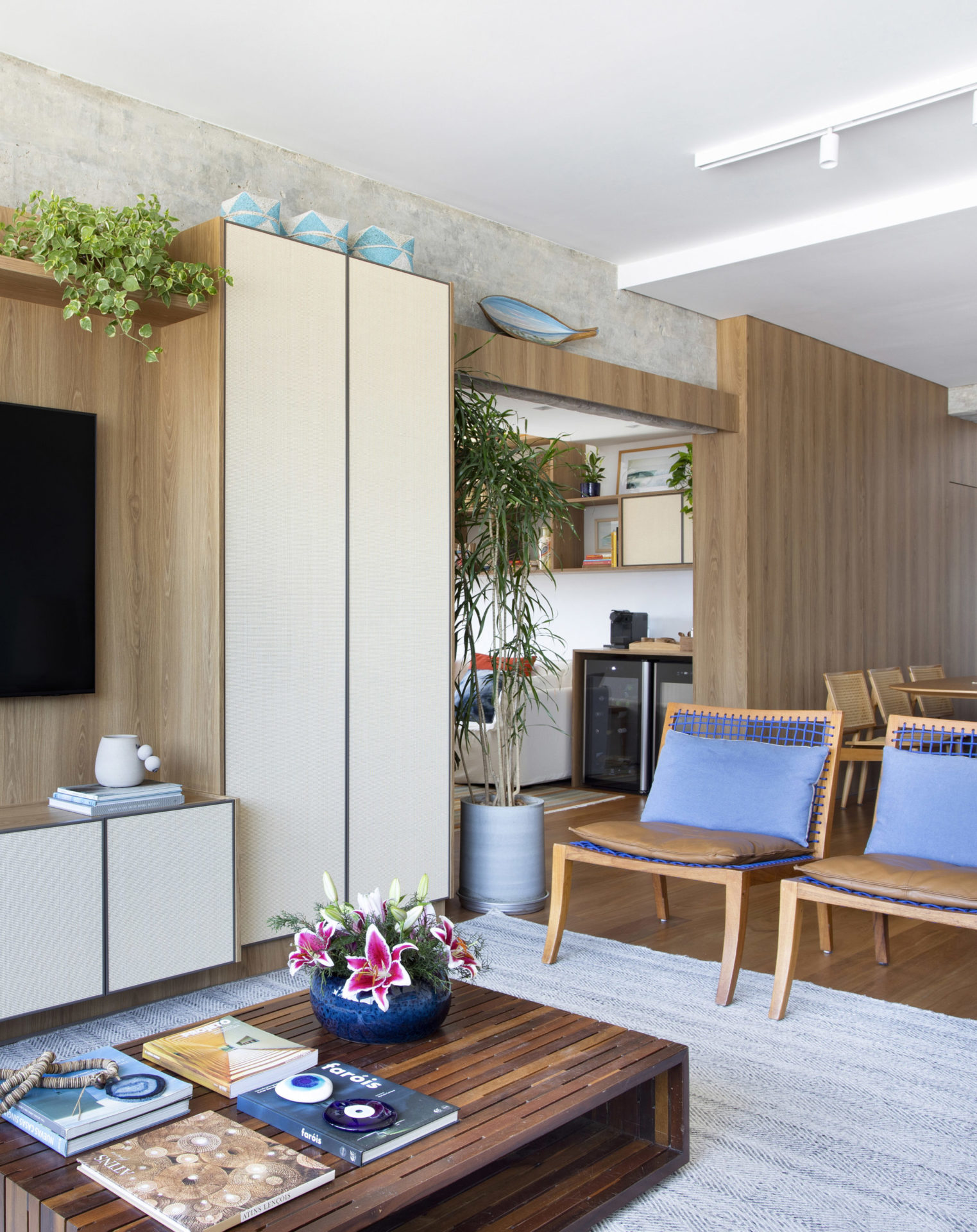 na foto sala com duas poltronas em madeira, mesa de centro e tv