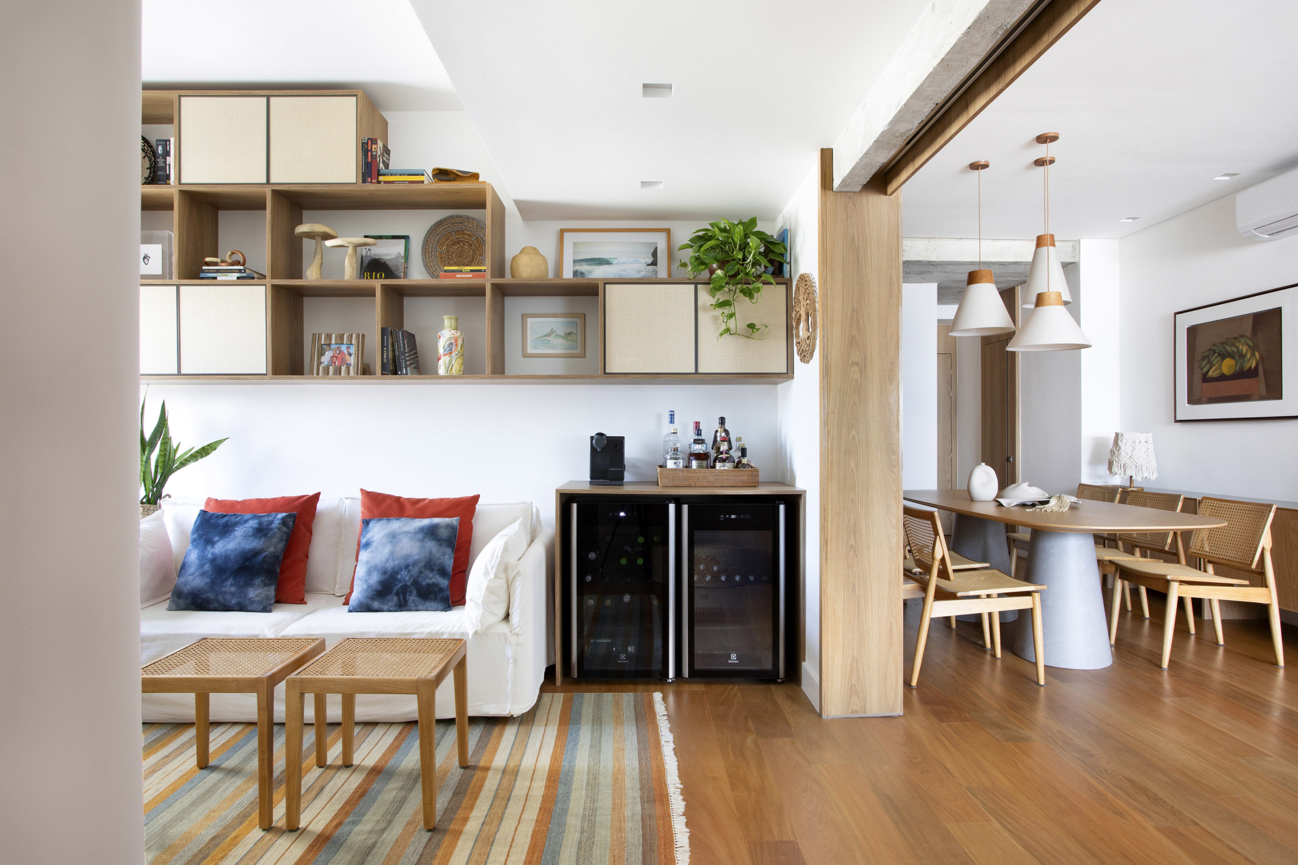 na foto sala de convivência com sofá e adega e sala de jantar