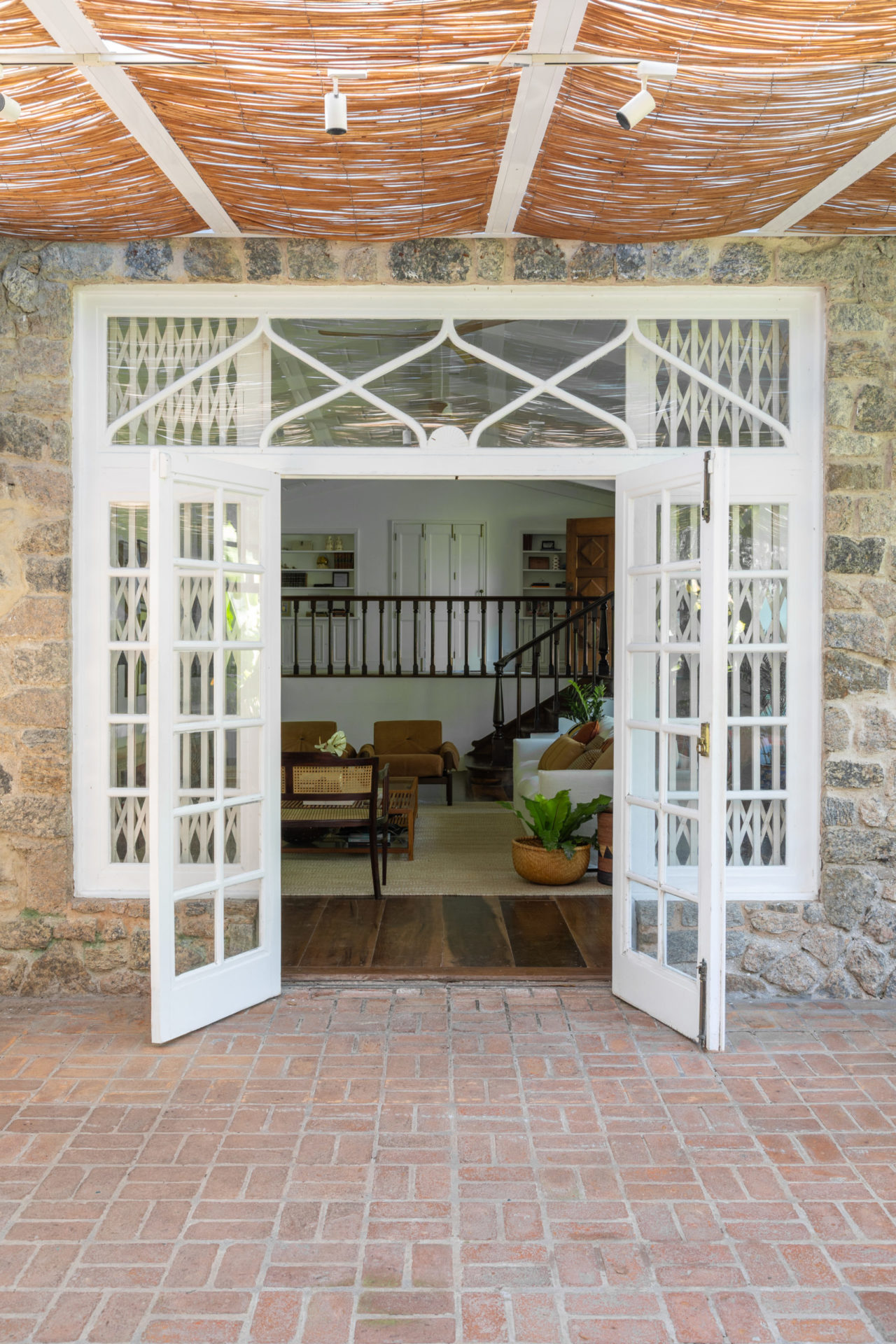 na foto entrada da casa com portão branco aberto