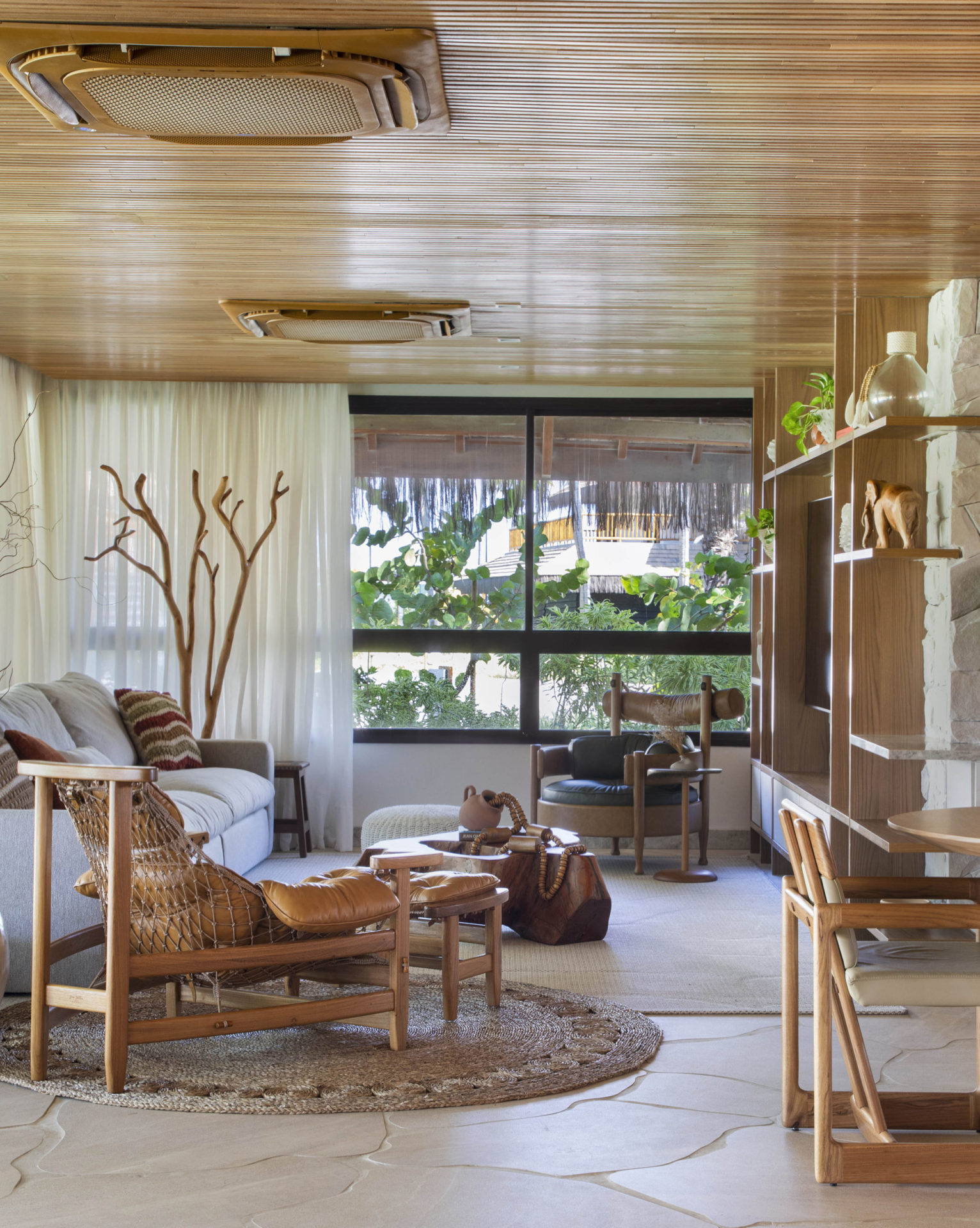 na foto sala de estar e TV com poltrona Jangada, de Jean Gillon