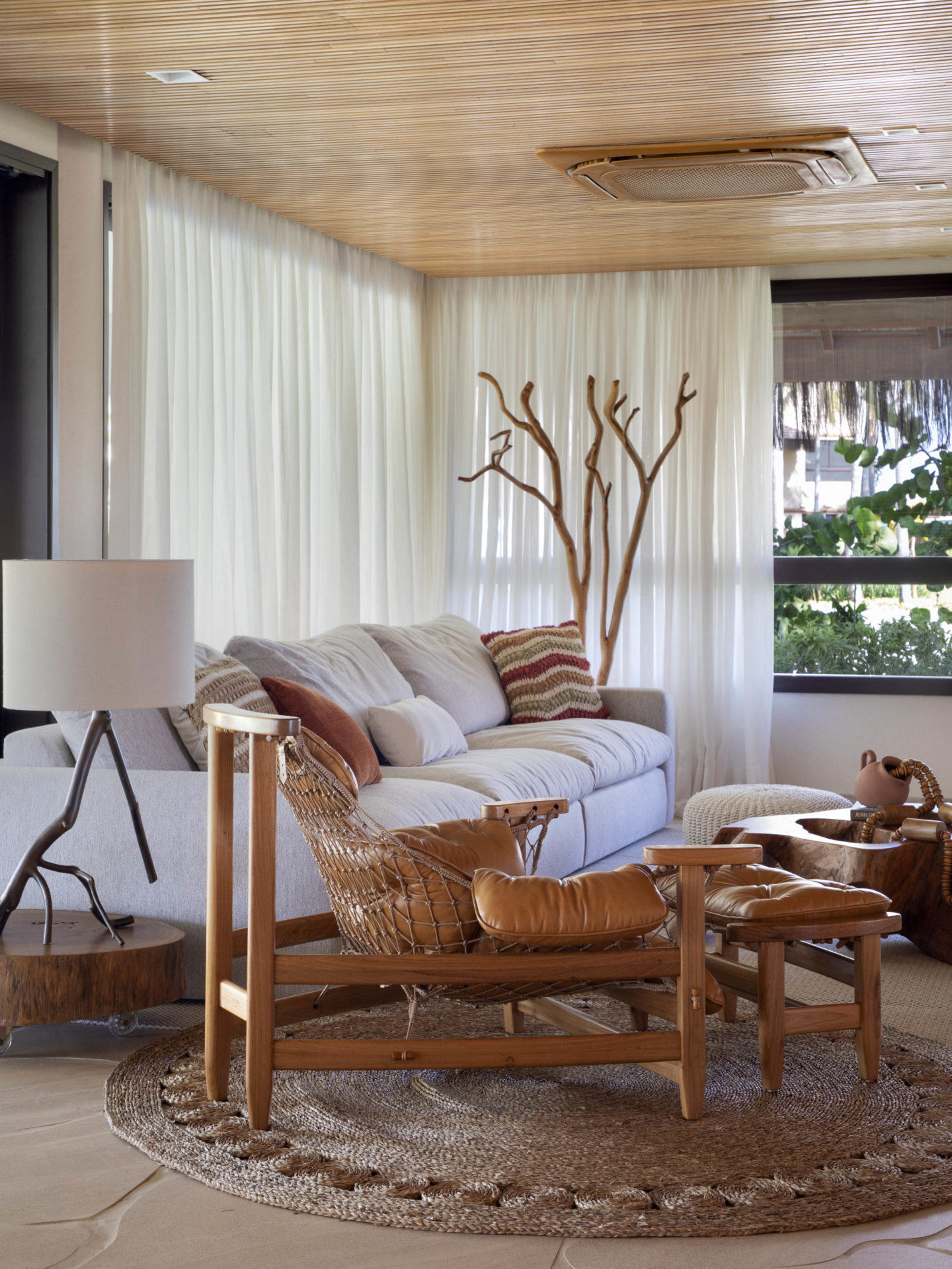 na foto sala de TV de casa de praia com poltrona Jangada, de Jean Gillon