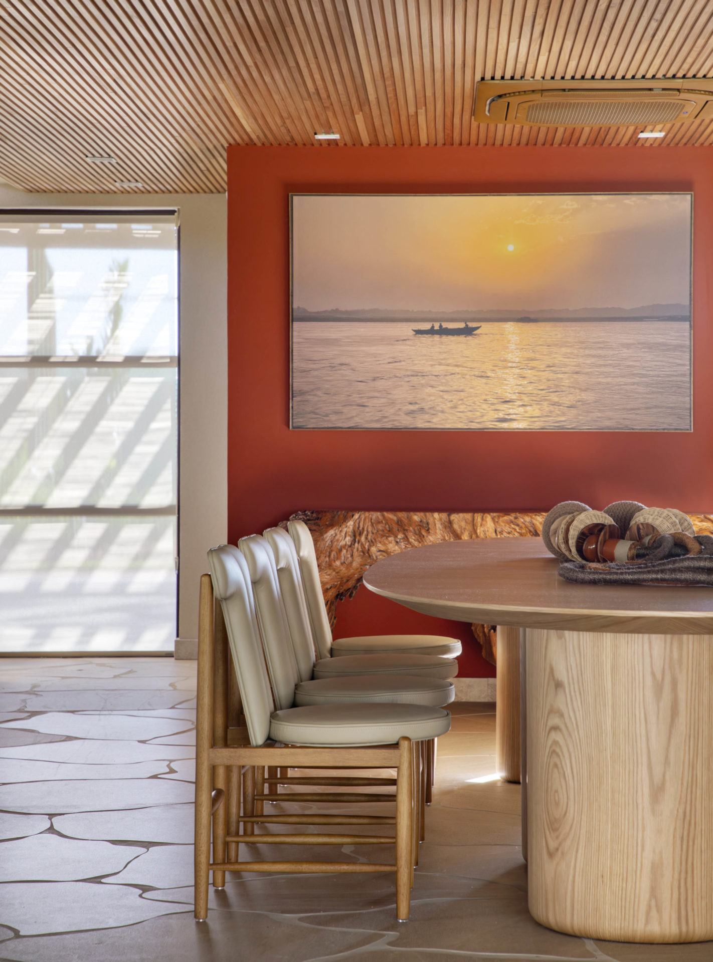 na foto sala de jantar com mesa de madeira e um quadro com a foto de um pôr do sol na parede