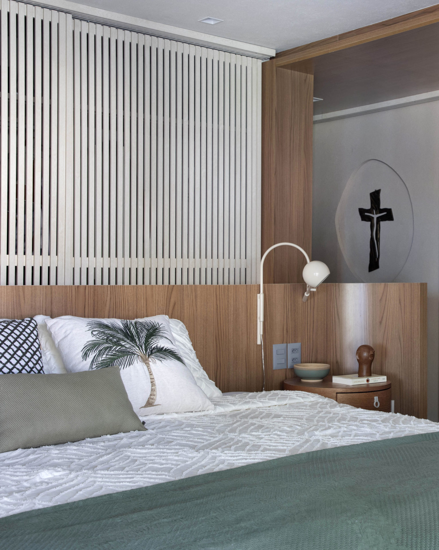 na foto quarto com cama de casal, mesa de cabeceira e luminária